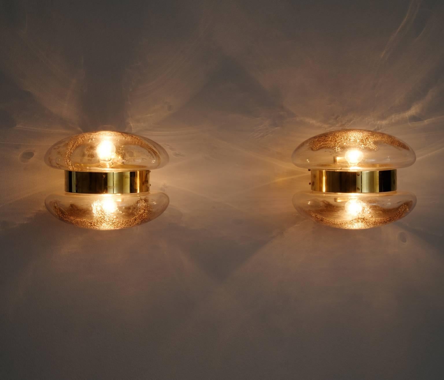 Pair of wall lamps, in brass and art glass, Italy, 1950s.

Stunning pair of wall lights. These wall-mounted sconces have an incredible appearance. The glass shades on both sides are beautifully shaped and show an interesting structure in the glass.