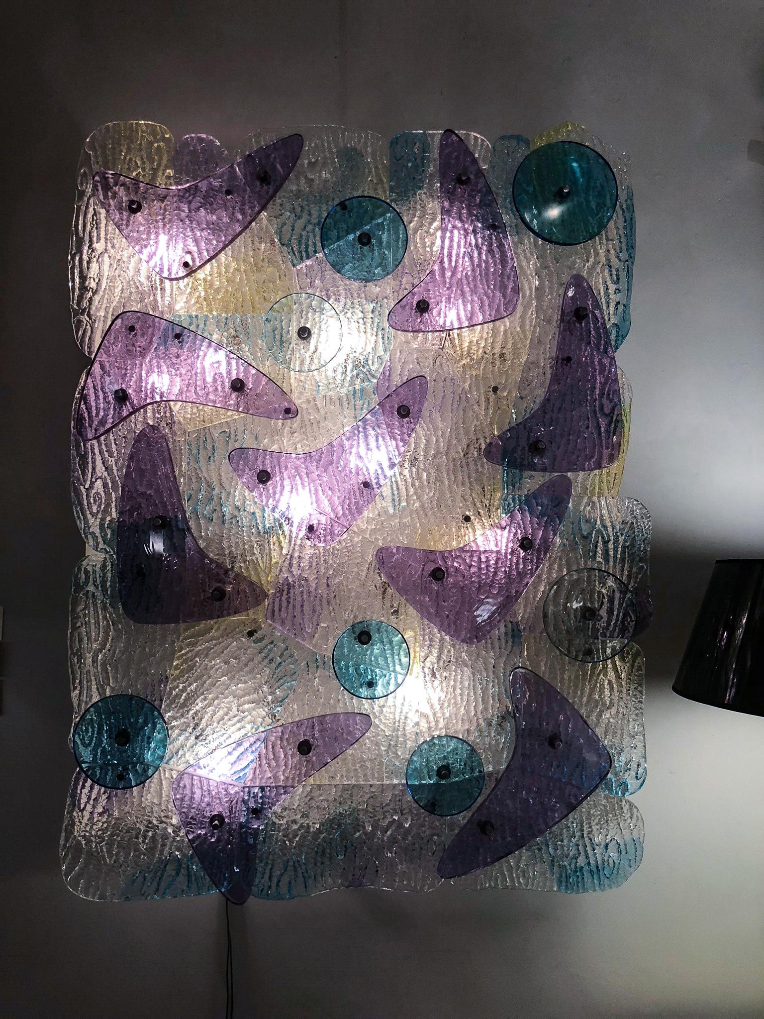 Interlocking glass segments with vivid yellow-green and transparent blue patches beneath large violet glass “boomerangs” and cyan blue discs. Signed on the glass “Archimede Seguso, Murano 1973.” Non-UL electrified.
