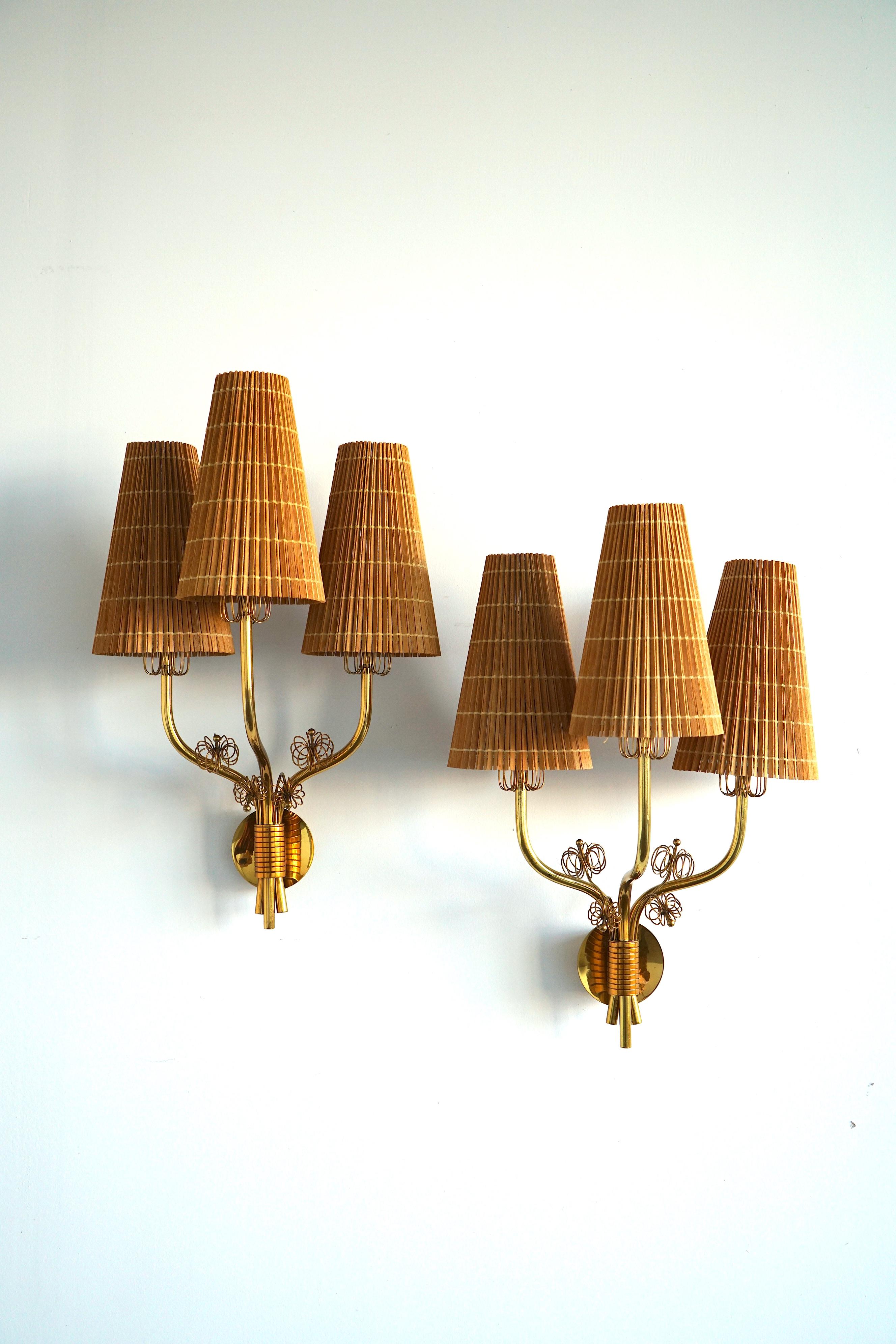 A pair of large wall lights designed by Paavo Tynell (1890-1973).
Polished and lacquered brass with brass wire decor and wooden shades.
Similar example featured at Idman catalogue , Model 9444.
This fixture produced by Arnold Wiigs Fabriken in late