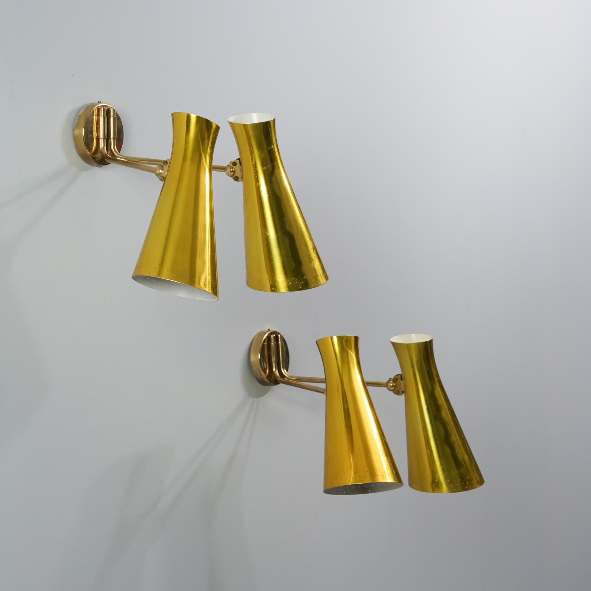 Pair of large wall lights, manufactured by Itsu, 1950s. Brass and painted metal. Adjustable lamp shades. Manufacturer's stamp. Good vintage condition, patina consistent with age and use. The wall lights are sold as a set. 