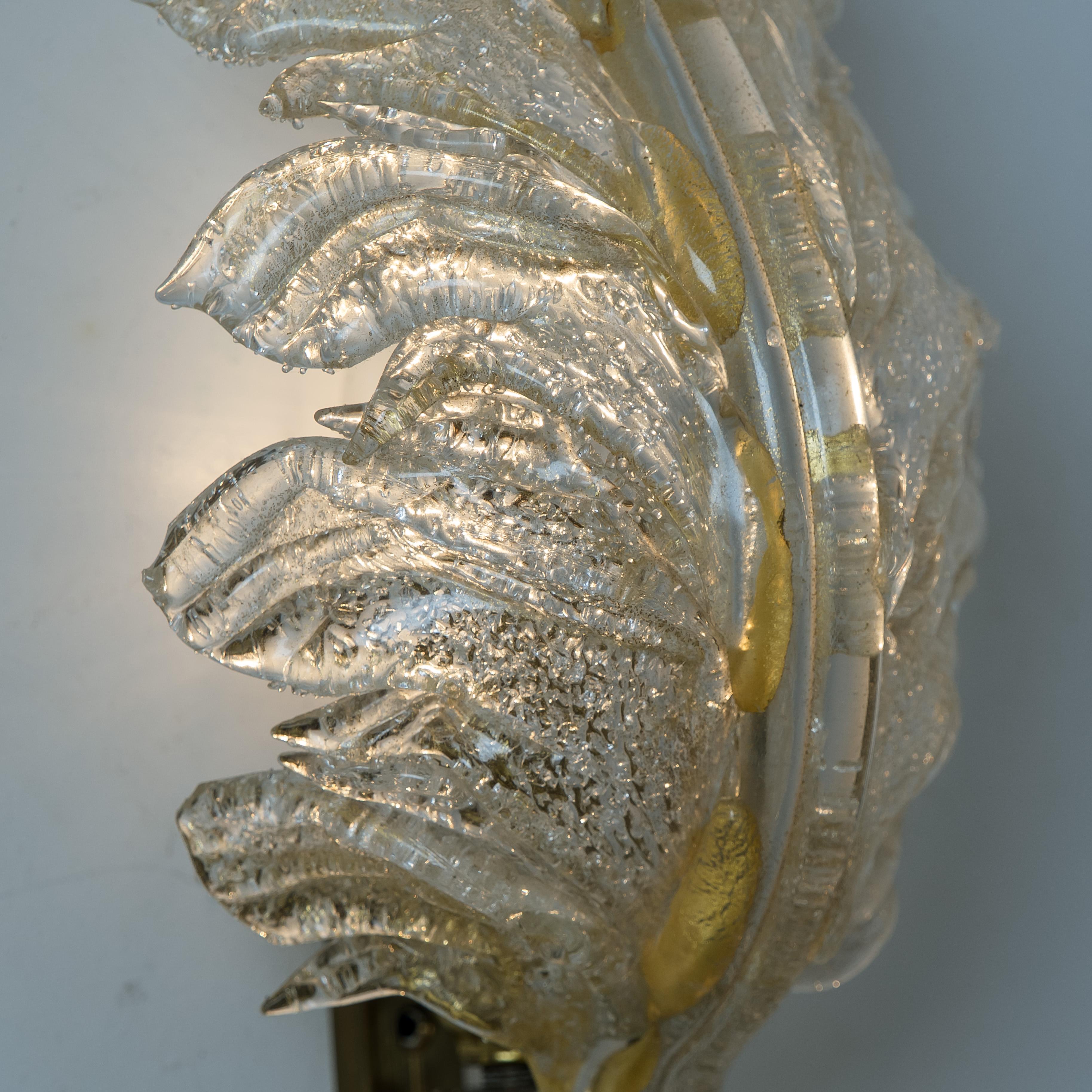 A pair of elegant and exquisite hand blown Murano glass Barovier & Toso wall sconces with special gold inclusions. Each light fixture consists one blown Murano glass leave. Mounted on a brass frame. The leaves refract light beautifully. The flush