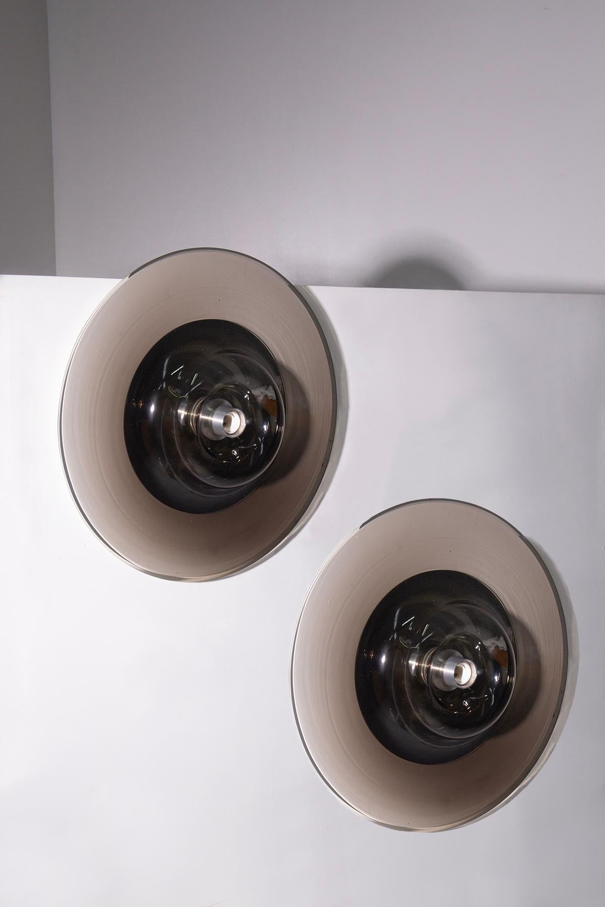 A rare and stunning set of two large Murano glass wall sconces, designed by the renowned French designer Pierre Cardin for the prestigious Italian manufacturer Venini in the 1970s. Refined and elegant, these sconces represent the perfect fusion of