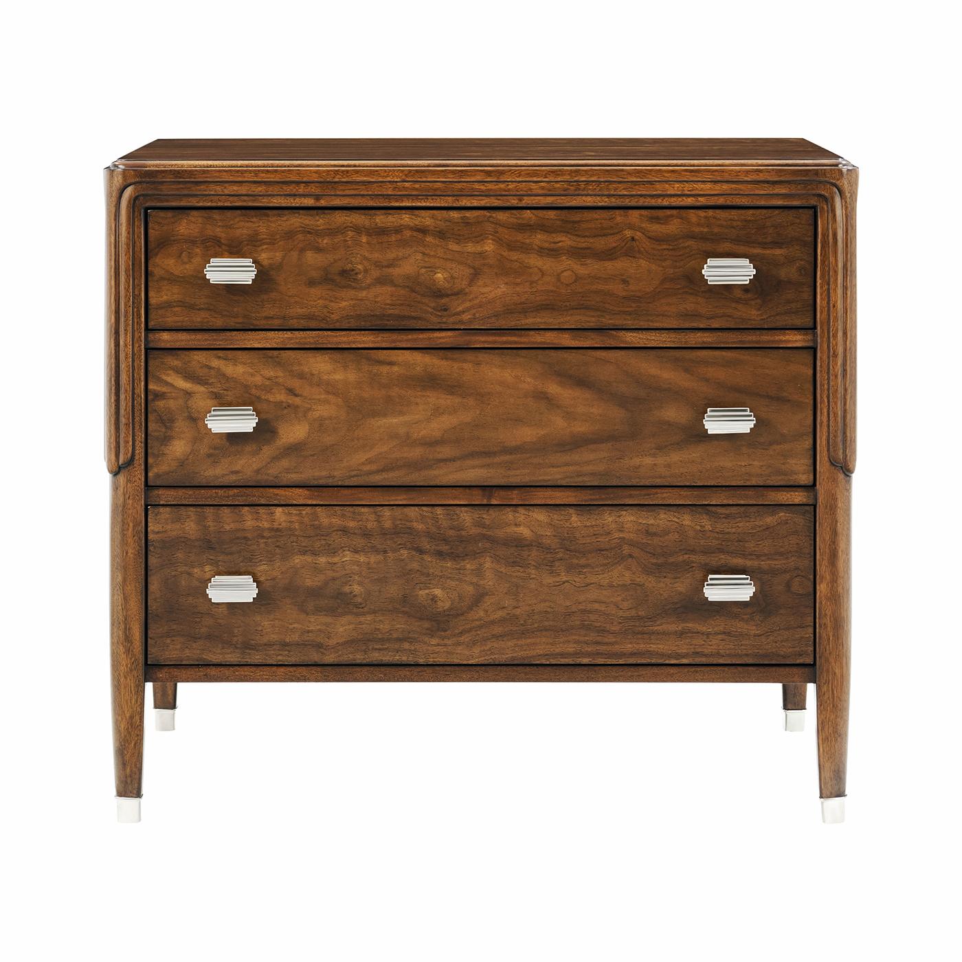Embodying the refined luxury of early 20th-century design, this bedside chest is crafted with exquisite figured walnut, showcasing a rich wood grain that adds depth and character. Its poised silhouette is enhanced by expertly tapered legs and subtle