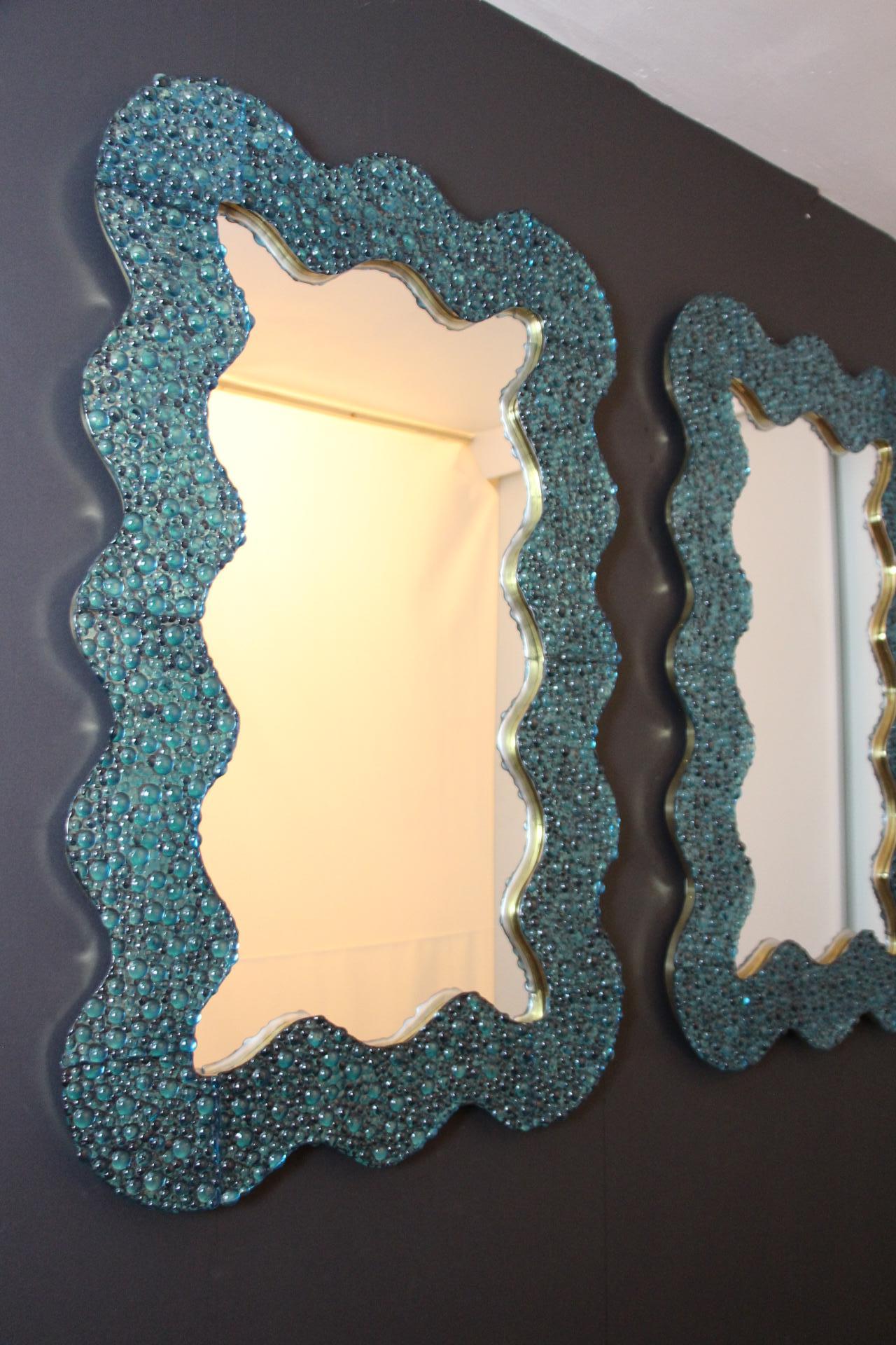 Ces miroirs bleus en verre de Murano sont absolument époustouflants. Tout d'abord, sa forme ondulée est très inhabituelle et procure une sensation très douce et inhabituelle. Ensuite, la texture du verre est vraiment spectaculaire, on dirait des