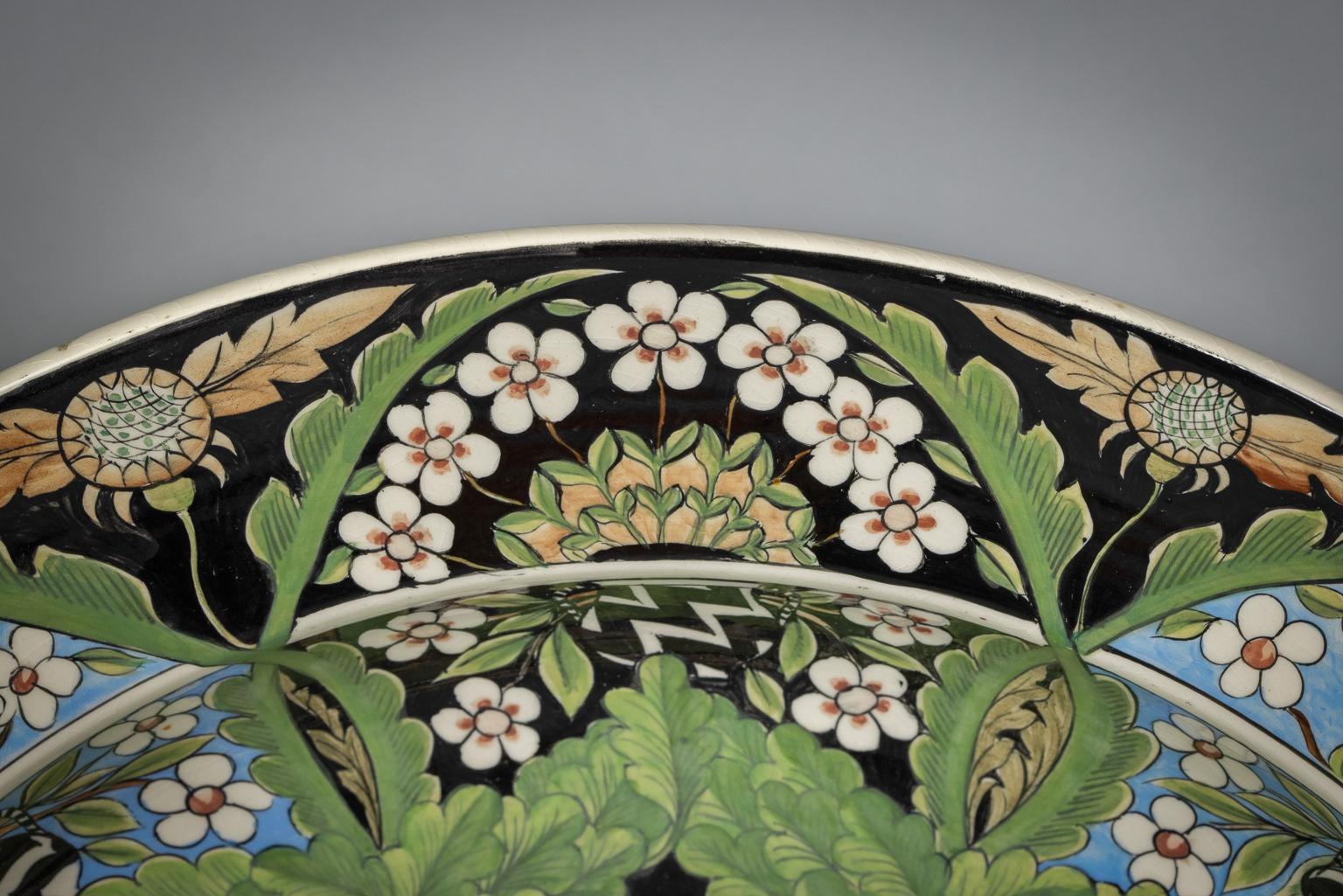 Each painted in the center with either an owl or a peacock roundel, within a band of exotic and woodland animals amongst oak trees, the upper branches of the trees forming arches around the rim enclosing eight panels of flower-filled vases on an