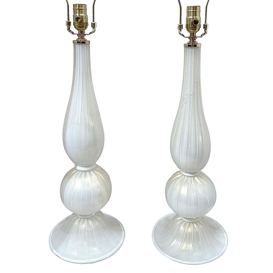 Coppia di lampade da tavolo in vetro bianco e oro degli anni '60 circa.

Misure:
Altezza del corpo: 21,5
Altezza del paralume: 32