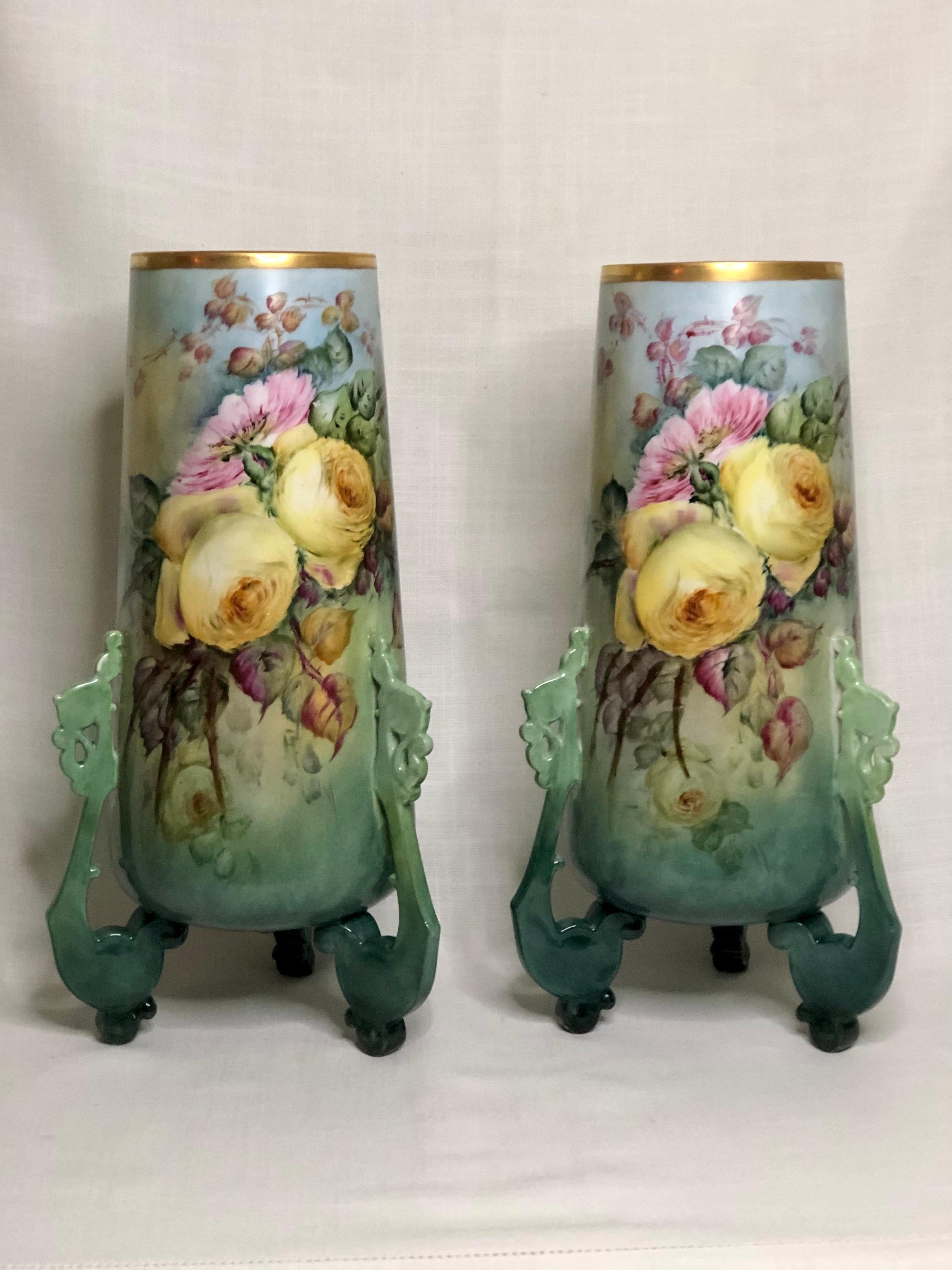 This is a magnificent pair of large Limoges porcelain vases, beautifully hand painted with yellow roses and pink peonies. They stand on three unusual feet as you can see in the attached pictures. It is very rare to find a pair of Limoges vases as