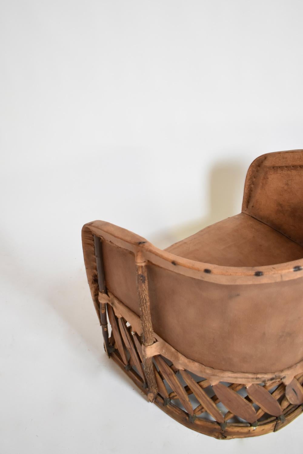 Pair of large wood and leather armchairs resting on a rectangular base formed by a crosspiece of raw wood, with leather seat and back. Mexico, 1970s.