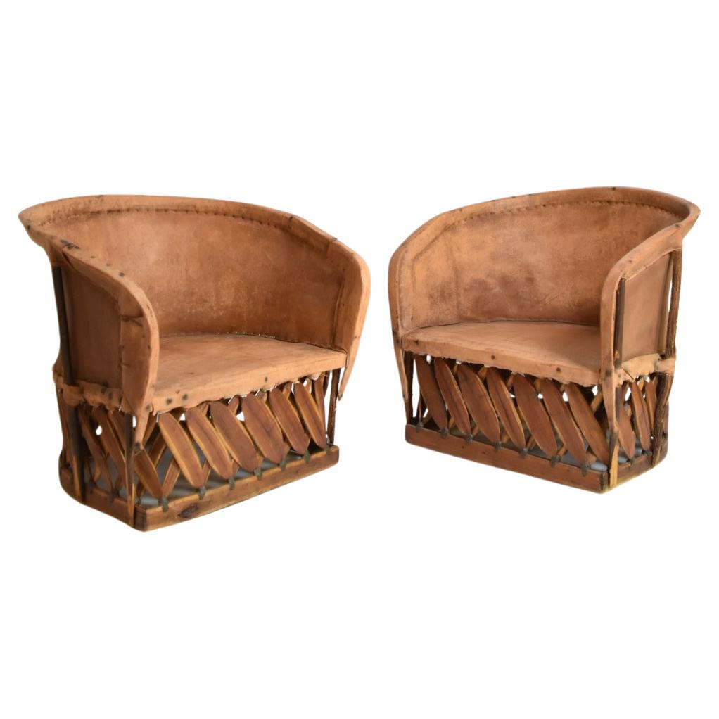 Pair of large wood and leather mexican armchairs, 1970s. in vendita