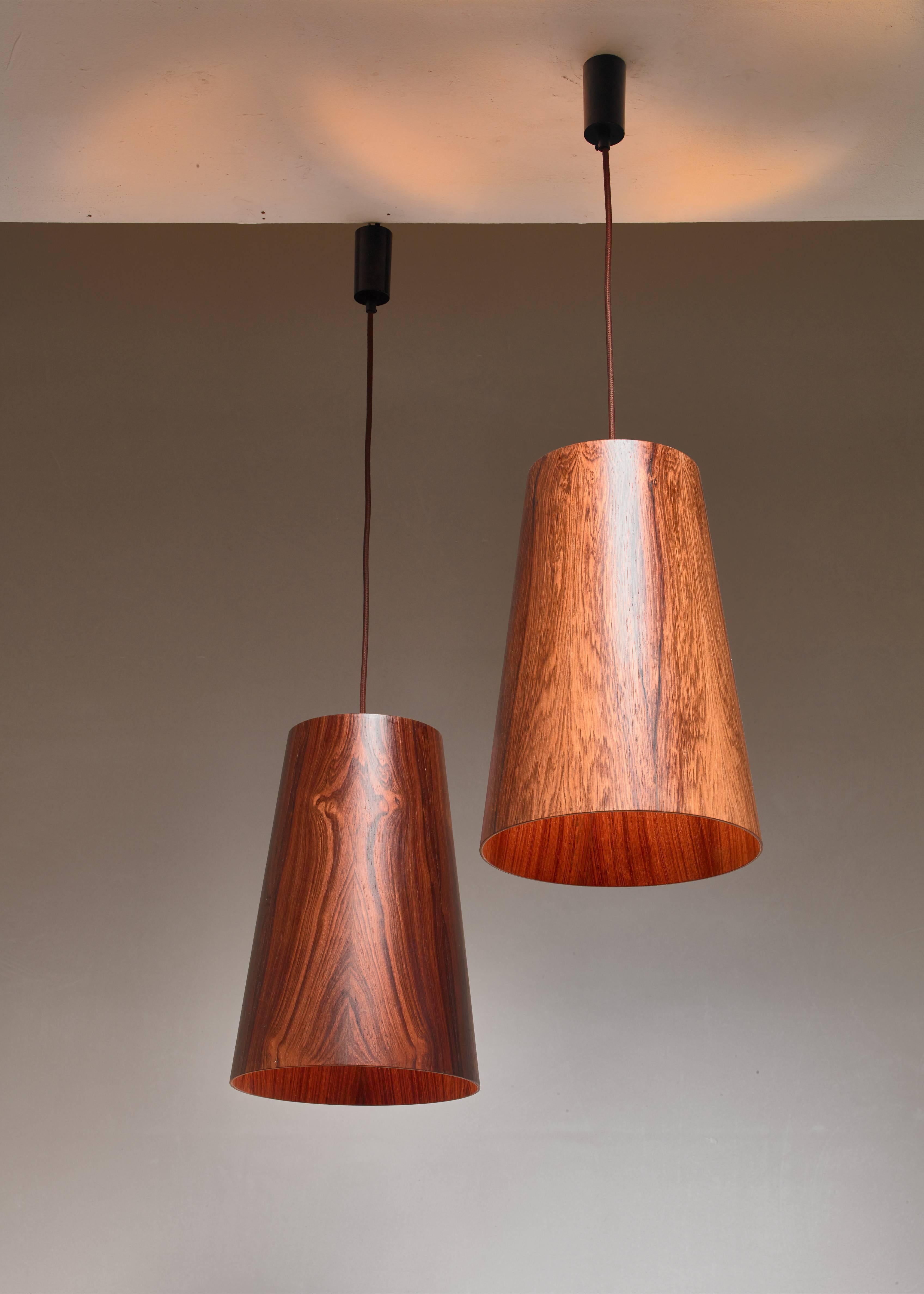 A pair of 1960s wooden pendant lamps, attributed to Östen & Uno Kristiansson for Luxus, Vittsjö, Sweden. The lamps are made of large (40.5 cm/16