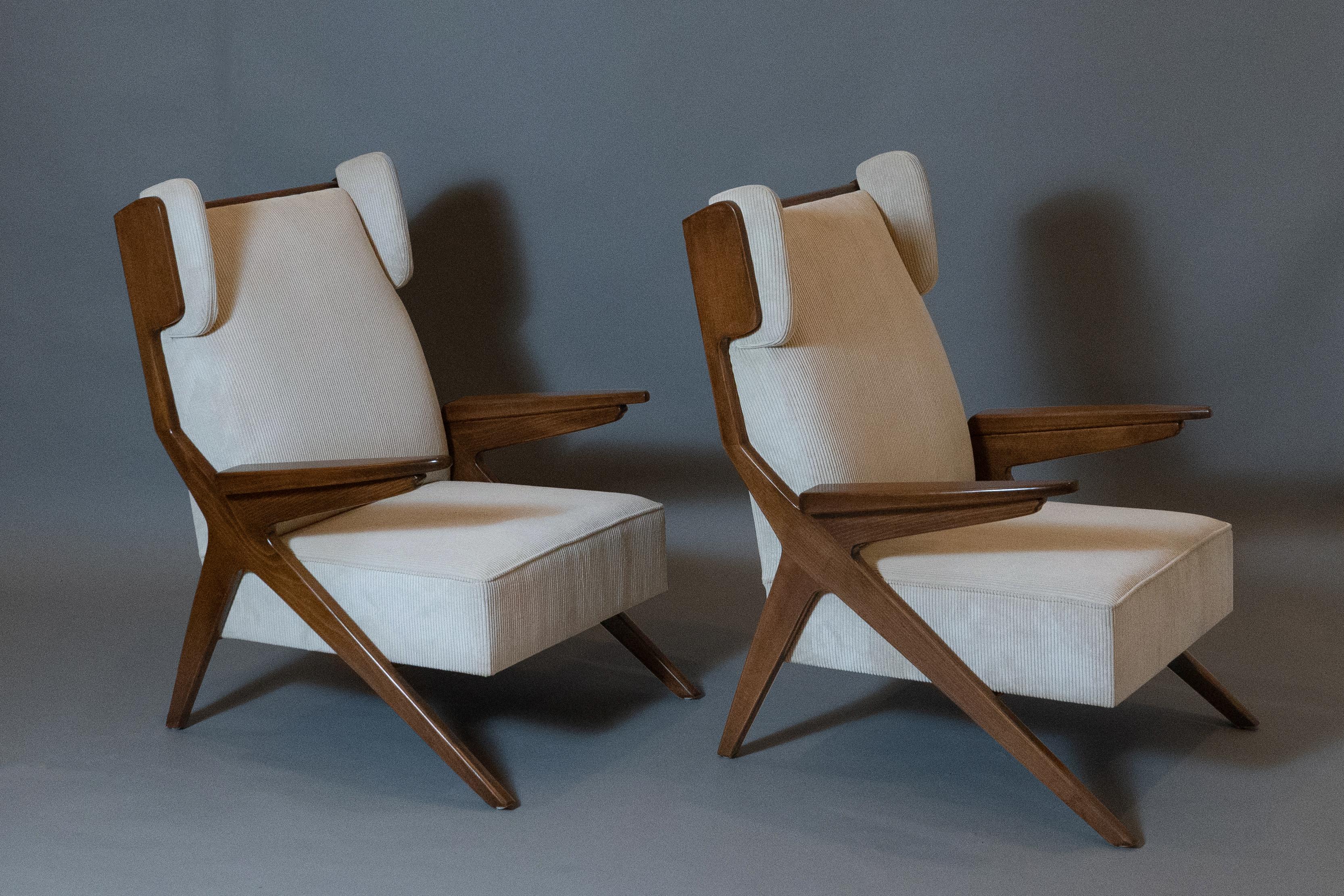 Augusto Romano (1918 - 2001) 

An imposing pair of Papa Bear wingback armchairs with scissor legs, in walnut and cream upholstery, by Torinese modernist architect Augusto Romano. The chairs' compass legs, highly geometric in profile, angle at one