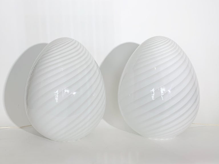 Larger Pair Itri Vetri Murano Translucent White Swirl Art Glass Egg Lamps, 1970's. Featuring hand blown spiral swirled glass shades with open 6 inch base. Radiant. Italian Modern. Statement lighting. Made in Italy. Parcel shipping methods may be
