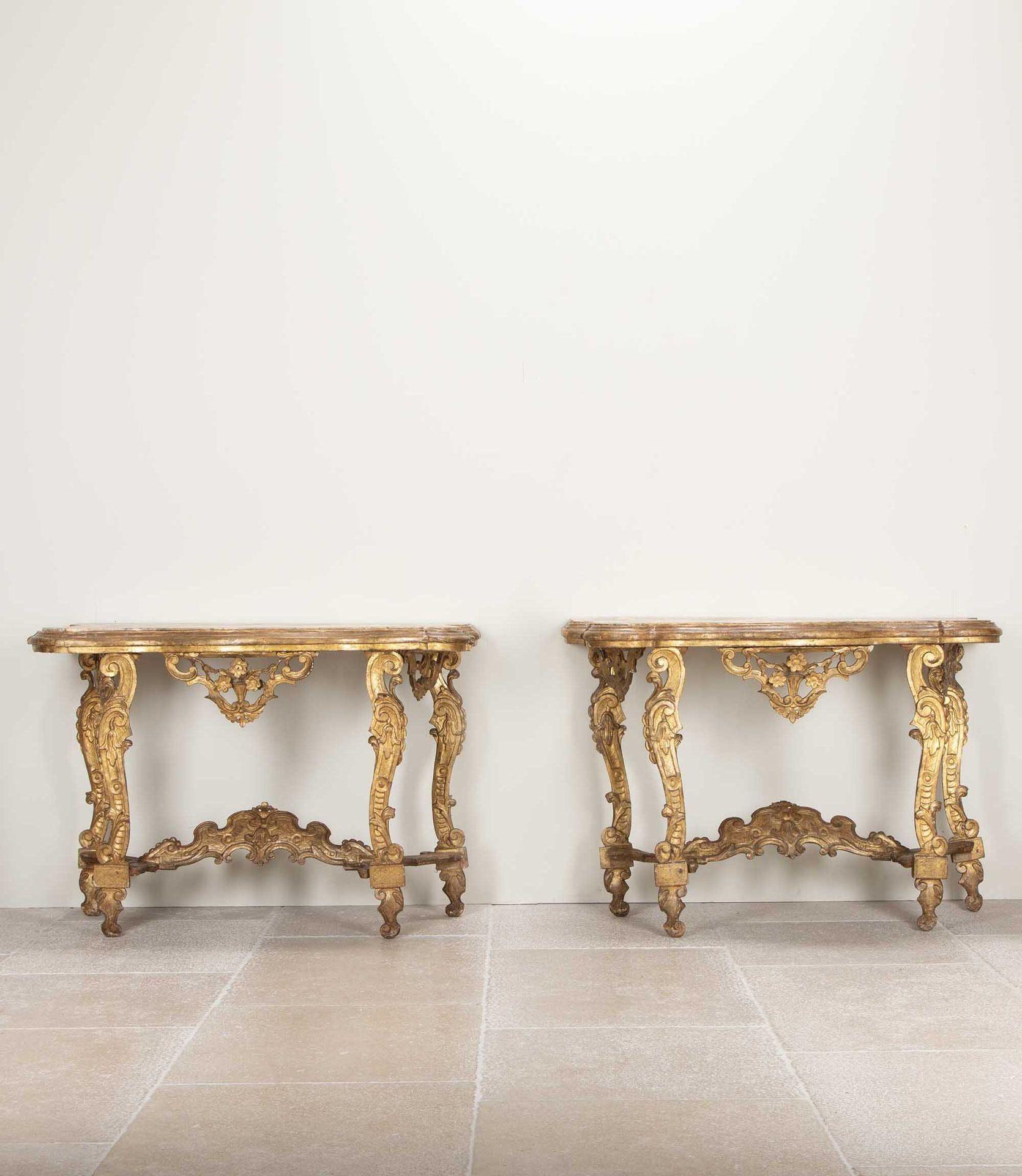 Paire de consoles italiennes en bois doré sculpté de la fin du XVIIe siècle ou du début du XVIIIe siècle.
Le plateau serpentin en fausse brèche violette peinte, surmonté d'une frise de cartouches à enroulements dorés et ajourés, repose sur des pieds