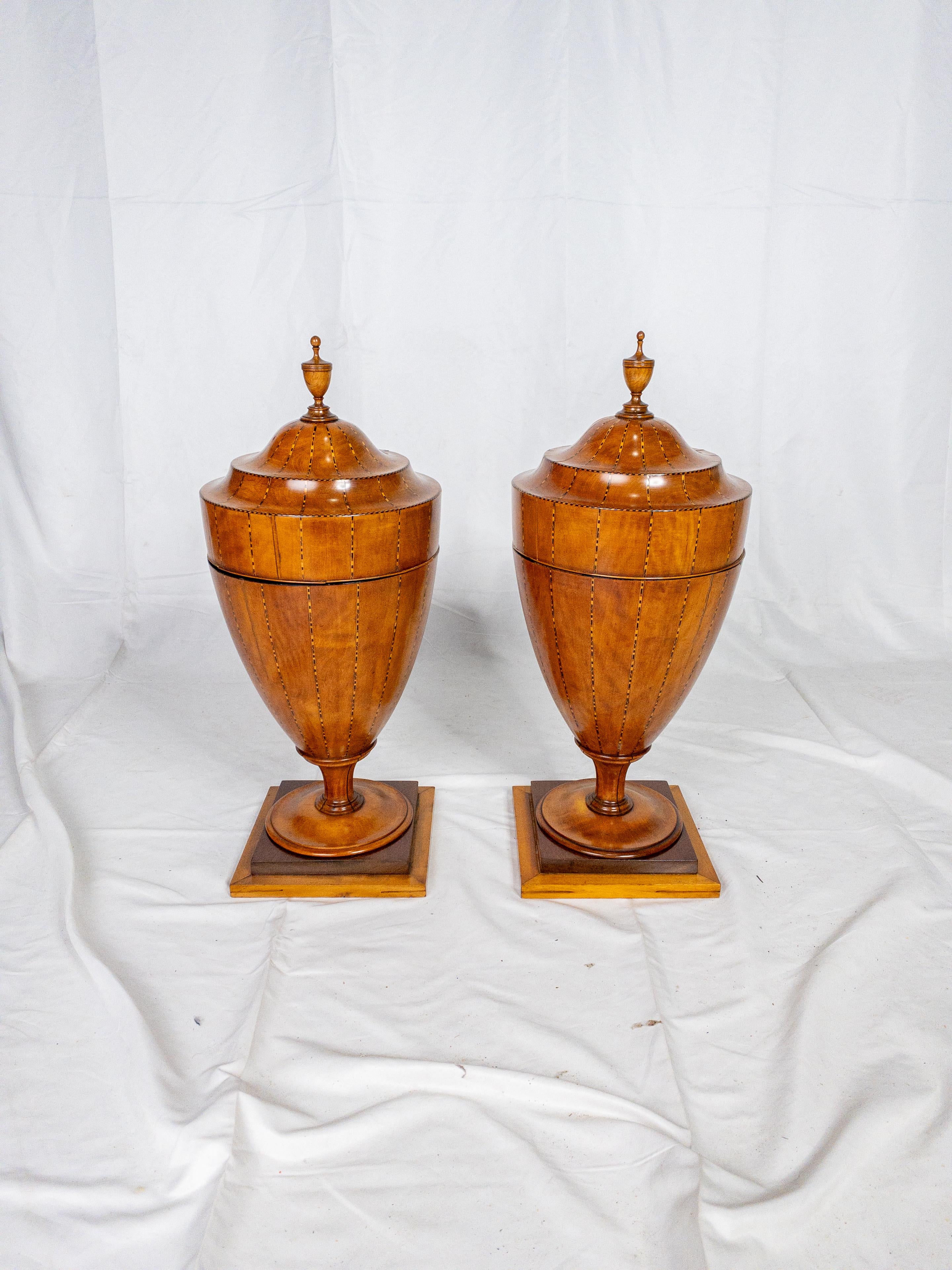 A pair of Late 18th Century Urn Shaped Cutlery Boxes represents an exquisite blend of craftsmanship and decorative artistry from the period. These boxes, designed for storing and displaying cutlery, are a testament to the fine woodworking skills of