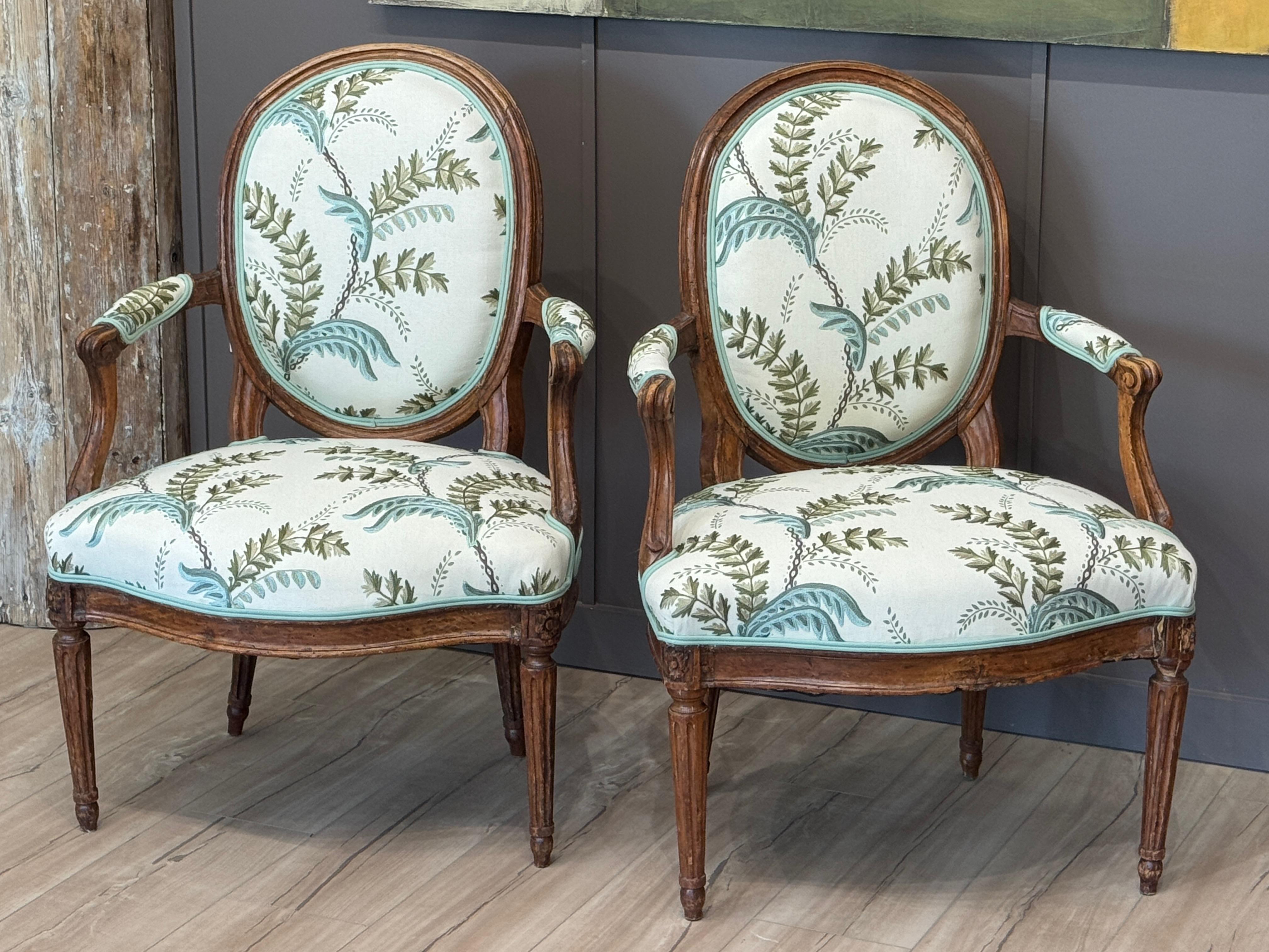 Gracefully carved with oval backs and fluted legs, this pair of late 18th century French fauteuils are constructed of beechwood and newly upholstered in Jane Shelton’s Acanthus Vine fabric. The soft, stylized foliage design brings freshness to the