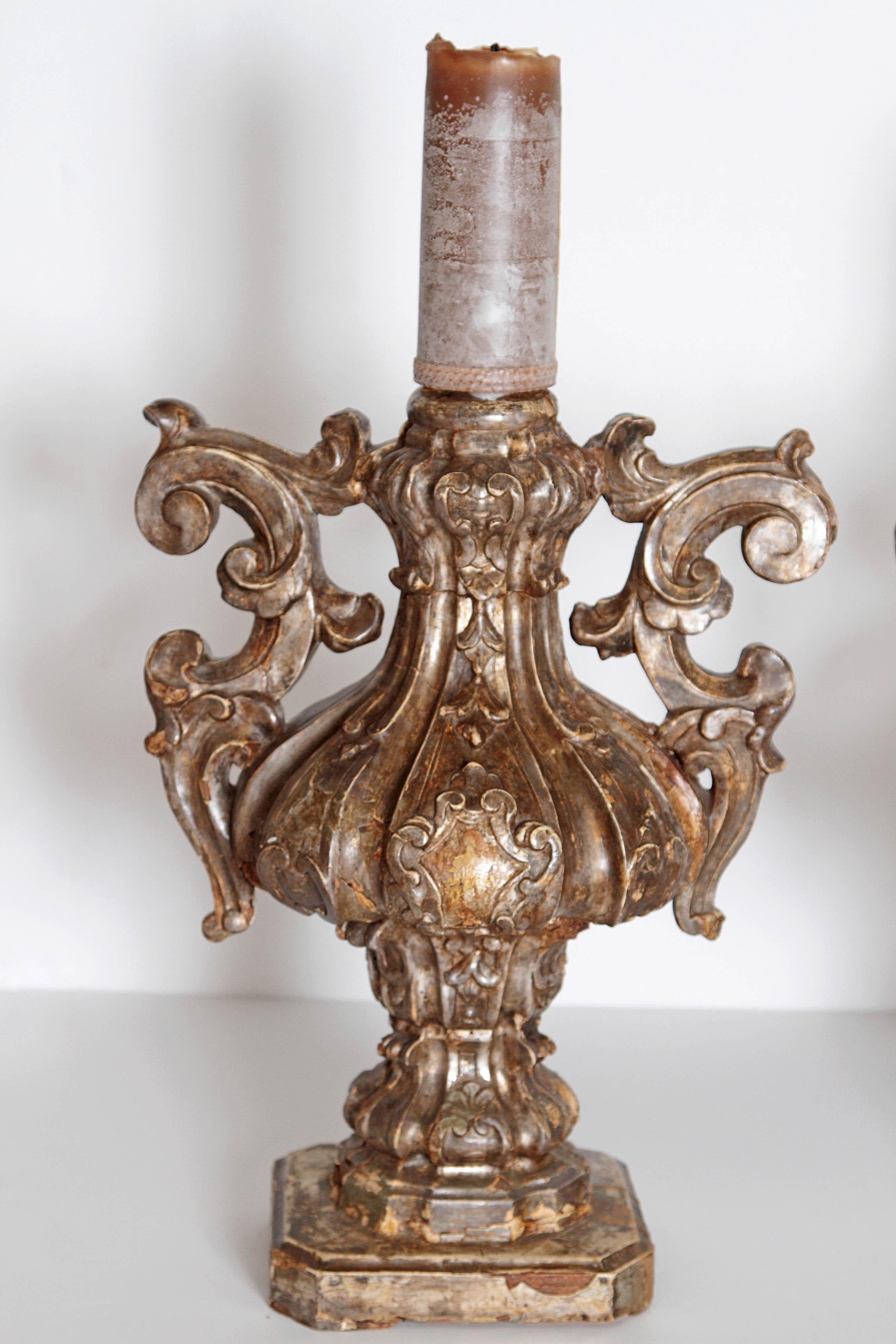 An impressive pair of late 18th century, Italian candleholders. Heavily carved giltwood with scrolls and melon shaped bodies on square bases.
