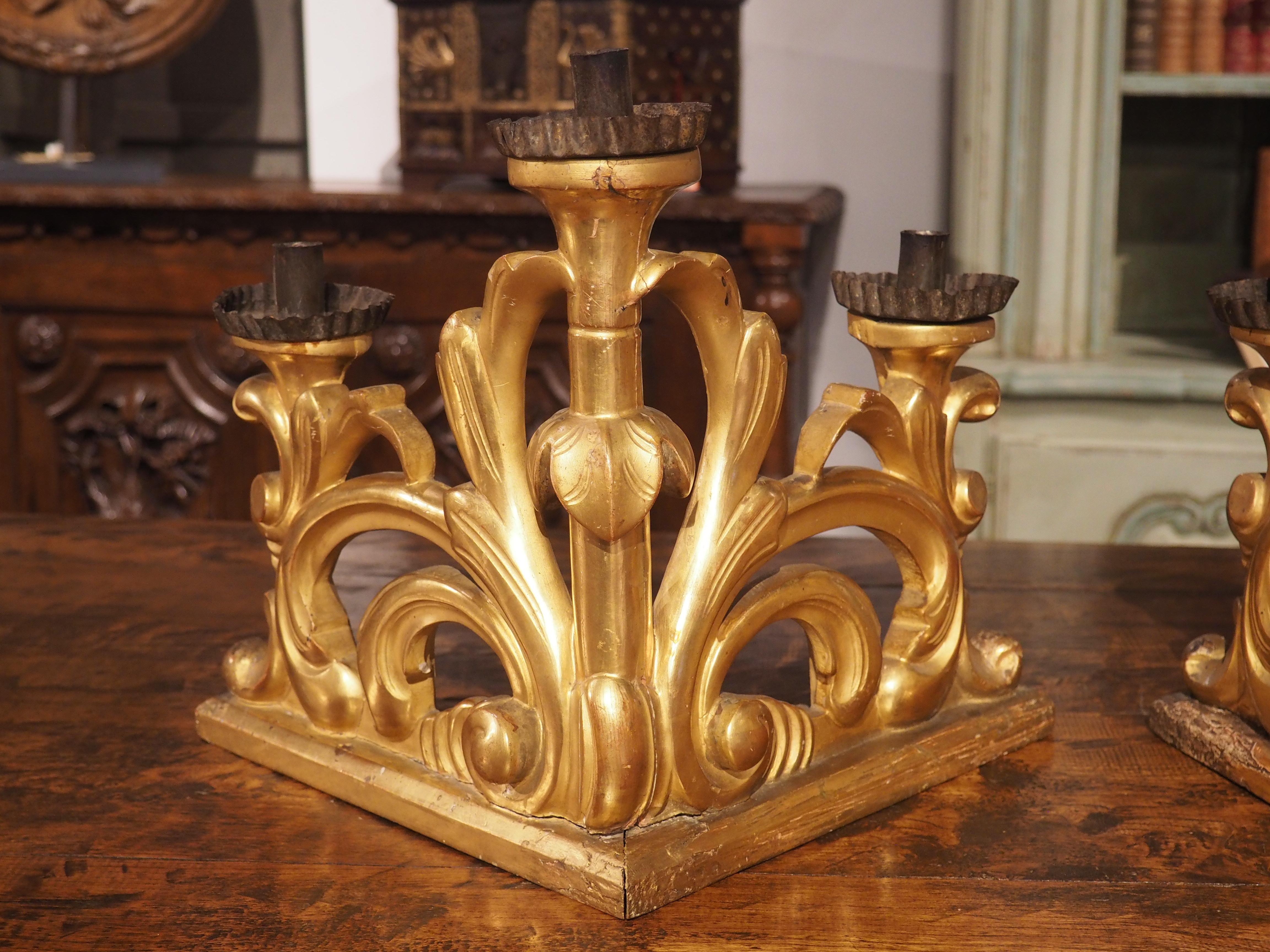 Avec leurs bases à angle droit et leurs lobes descendants, cette paire de chandeliers italiens en bois doré constitue une source de lumière unique. Sculptés à la main à la fin du XVIIIe siècle, ces chandeliers de la période baroque présentent une