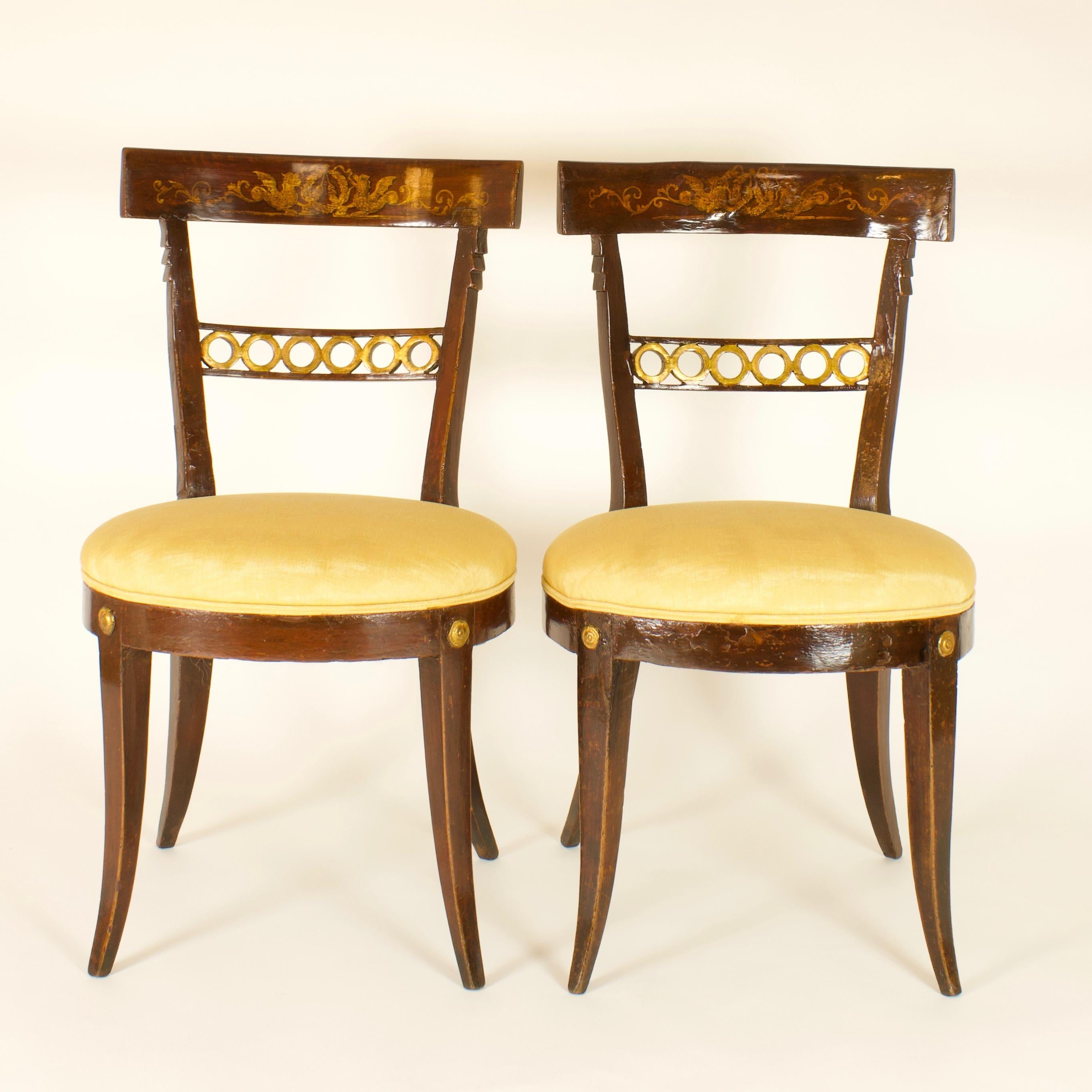 Pair of Late 18th Century Italian neoclassical Klismos Style side chairs

Exceptional pair of dark red varnished side chairs: the wide curving back with frieze decoration, the raked and canted front and back sabre legs based on the remarkable ranked