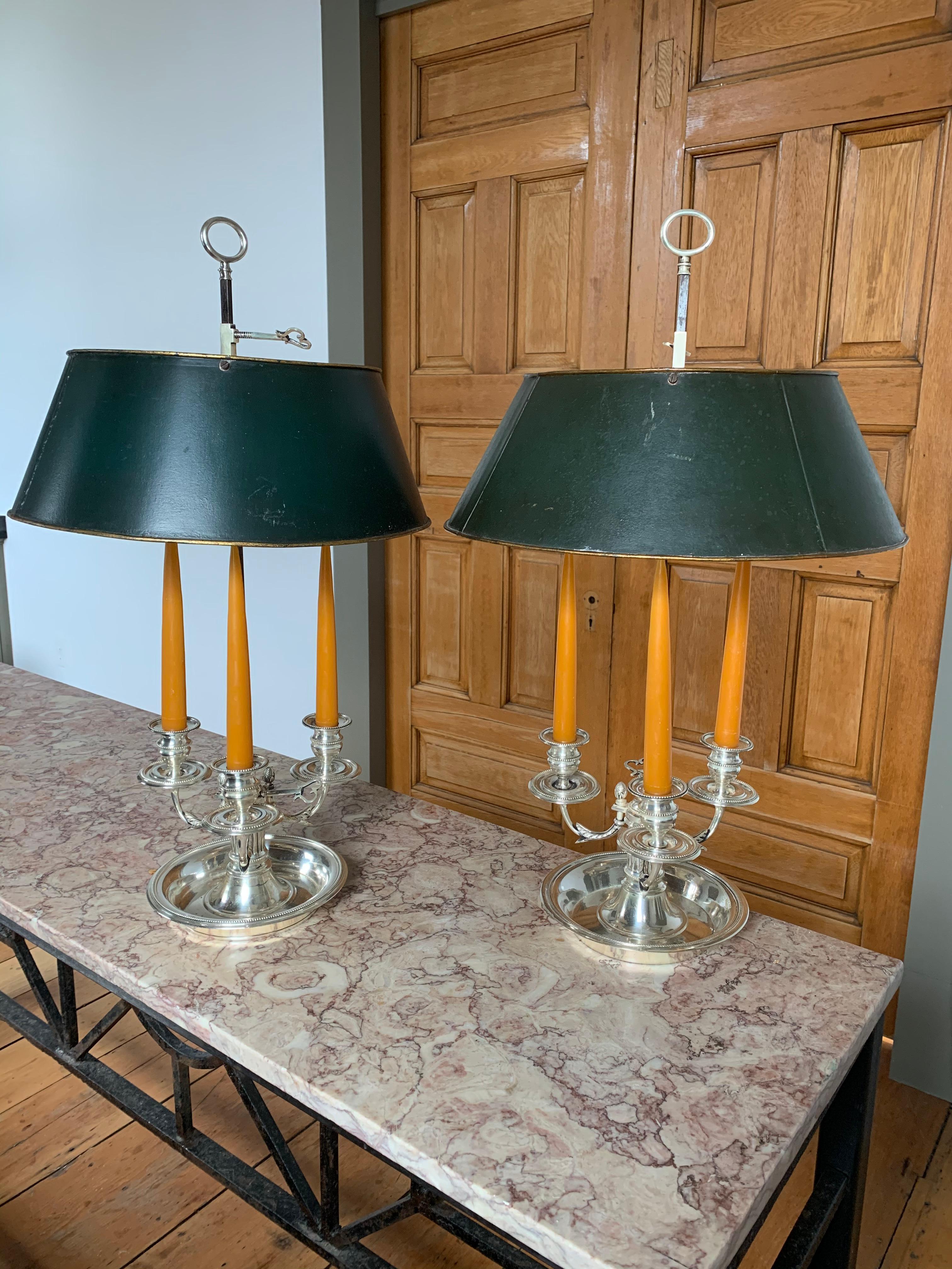 Pair of Late 18th Century Neoclassical Silver on Bronze Bouillotte Lamps.  All original.  Silvering original.  Tole shades move up and down as well as the candle arm grouping.  Well cast form.  Original bolts underneath.  Silver in very good