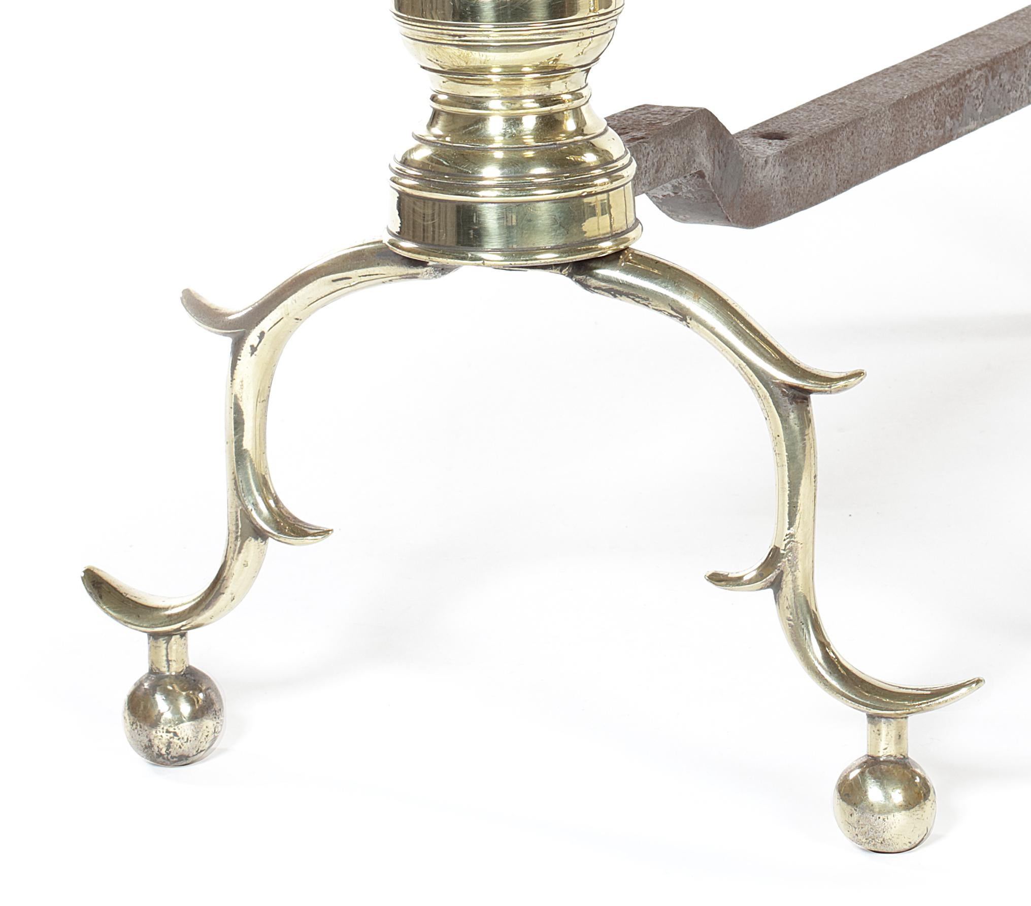 A pair of late 18th-early 19th century North American polished brass andirons
The turned supports on cabriole legs and ball feet, each 28 cm wide, 53 cm deep, 54 cm high (2).