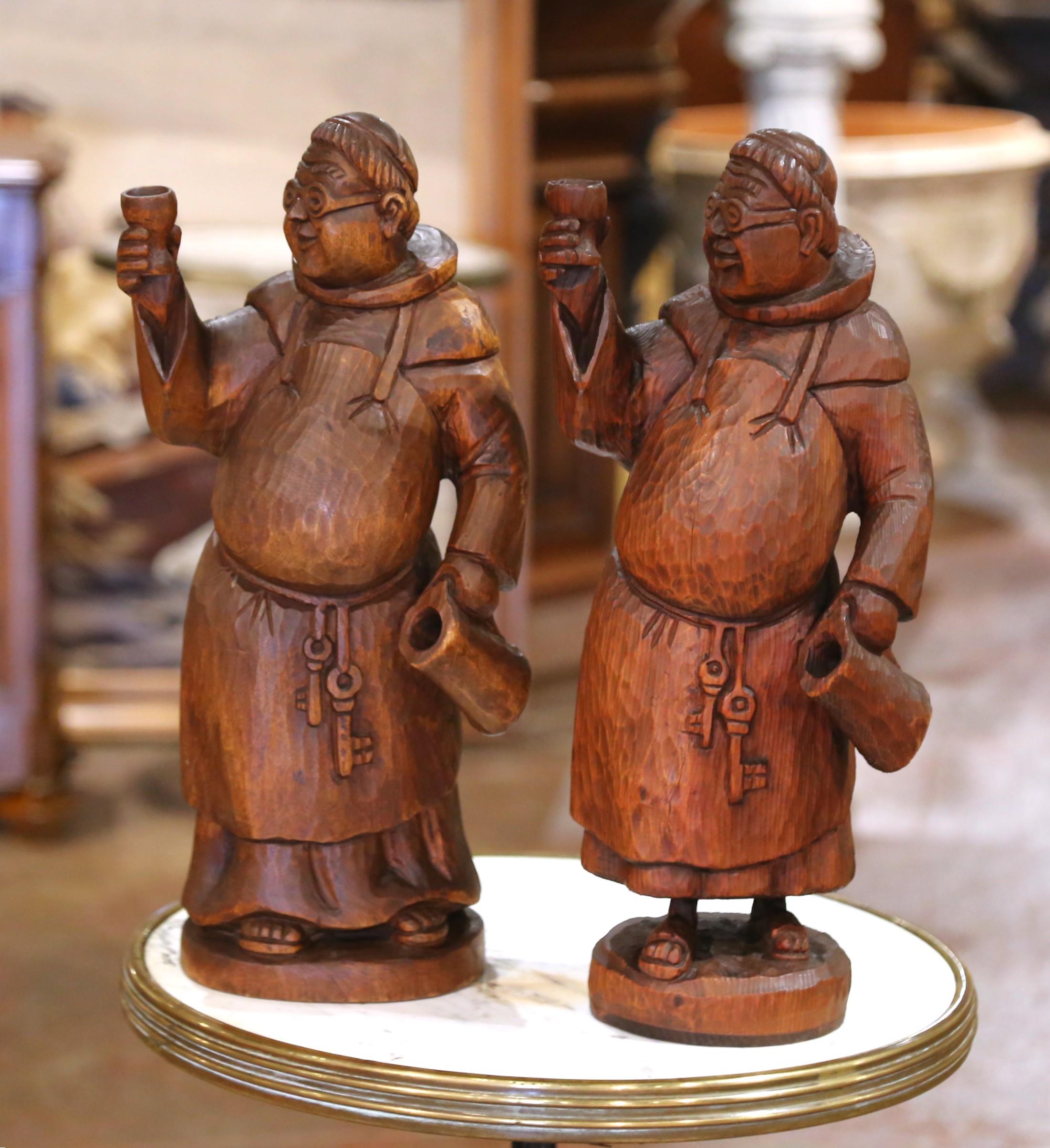 Sculptée en France vers 1890, cette paire expressive de figurines de moine en chêne ancien allie le charme gaulois à l'esprit rustique de la tradition de la Forêt-Noire. Chaque frère joyeux est représenté au milieu d'un toast, levant une coupe dans