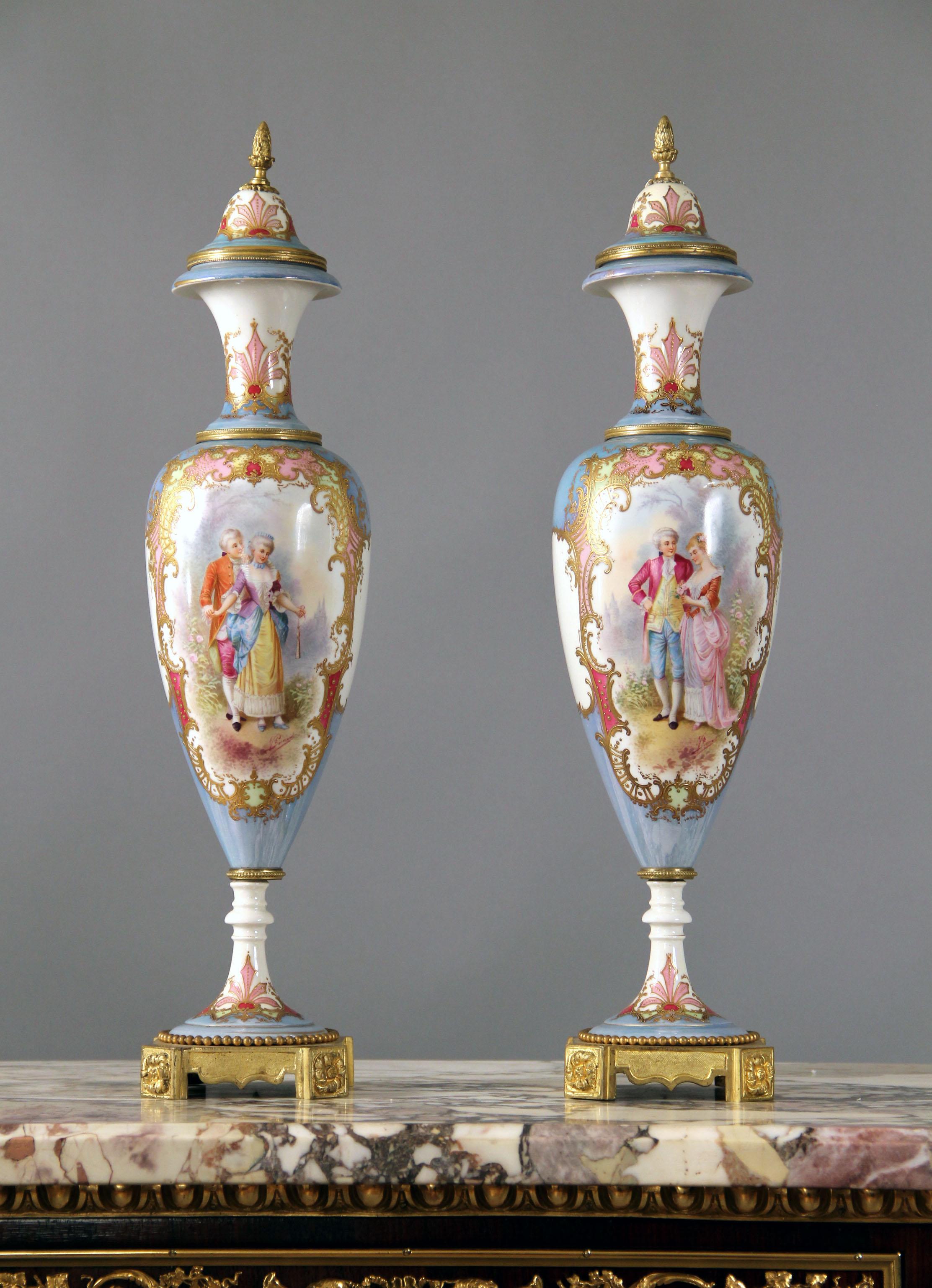 Coppia di vasi iridescenti in stile Sèvres montati su bronzo della fine del XIX secolo

Ciascuna di esse ha una forma allungata a balaustro e presenta una scena romantica finemente dipinta, il rovescio una scena fluviale con un castello sullo