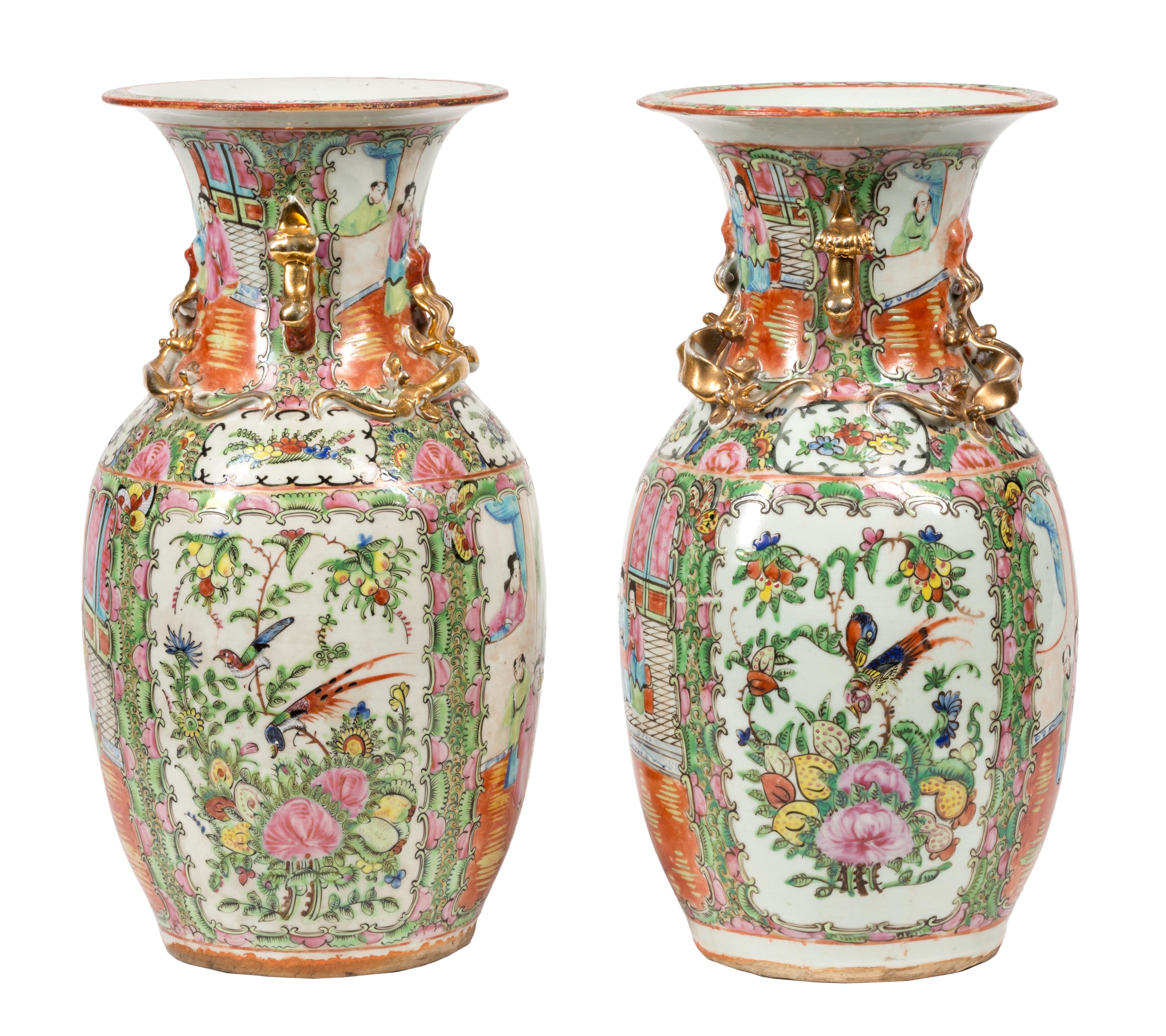 A pair of late 19th century Canton Chinese porcelain famille-rose urns / vases, featuring hand painted vegetation, birds, flowers and scenes of traditionally dressed figures. Around the necks are small raised sculptural dragons and foo dogs in gold.