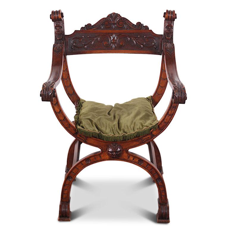 A pair of late 19th century carved walnut ‘Savonarola’ inspired armchairs with carved scrolled arms and uprights and a highly detailed carved back.