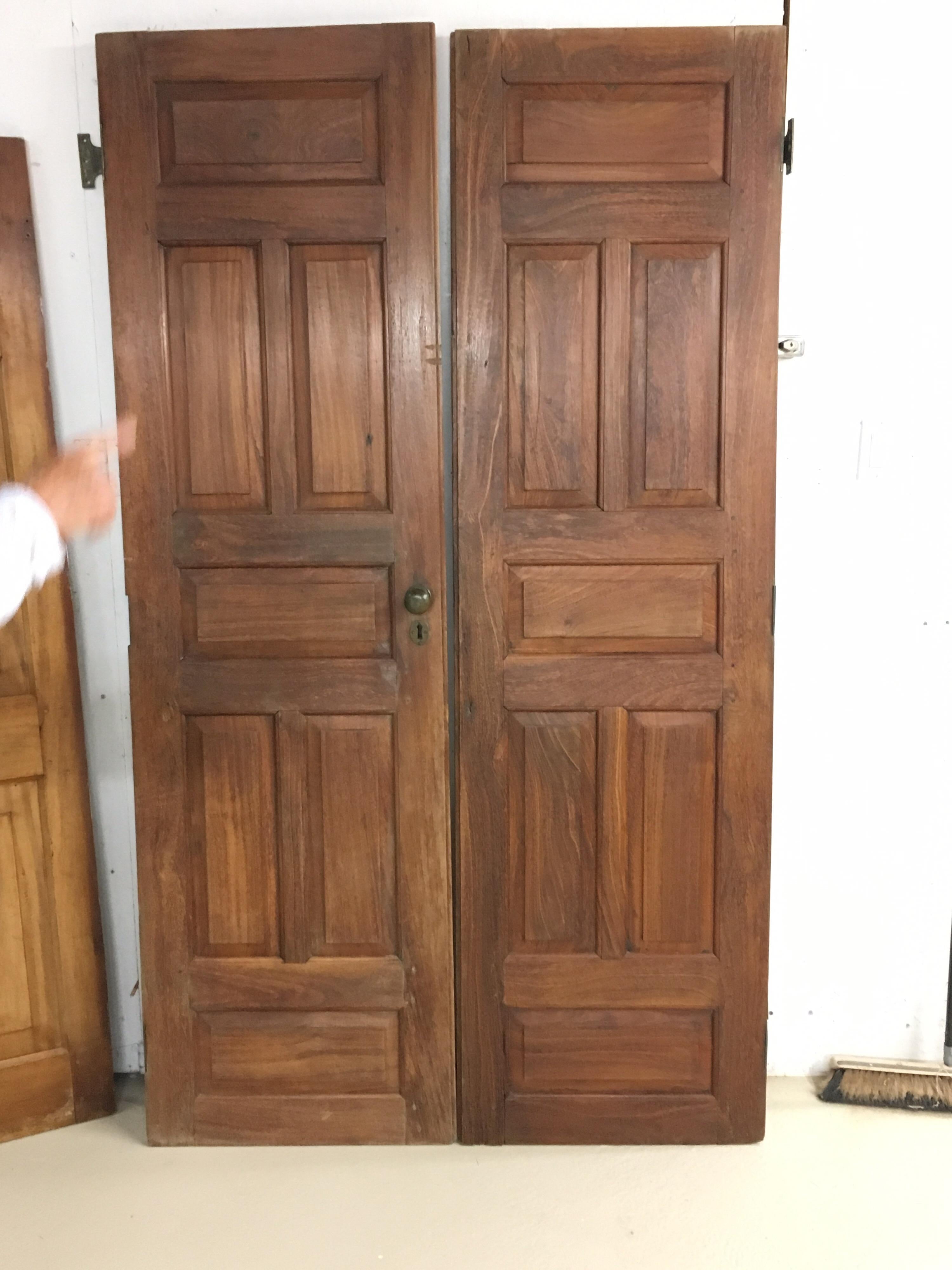 Pair of late 19th century Ceylonese solid rosewood Paneled doors, circa 1890s. Beautiful doors with original hardware. Doors meet and join together. Solid rosewood and great patina from age and use.

Provenance: Harrington Estate, importers of