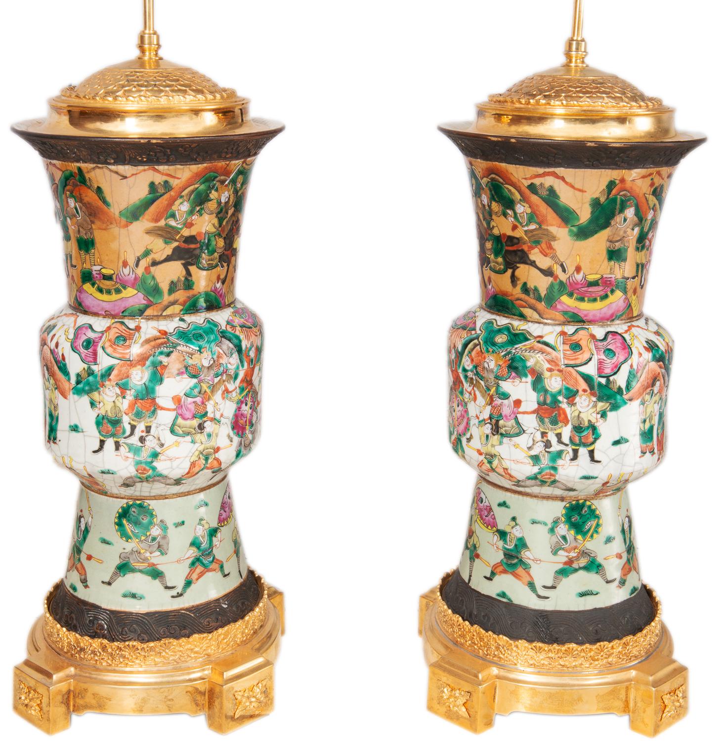 A pair of late 19th century Chinese crackle-ware vases/lamps. Each with various battle scenes with warriors on horseback, mounted with wonderful gilded ormolu lids and bases.