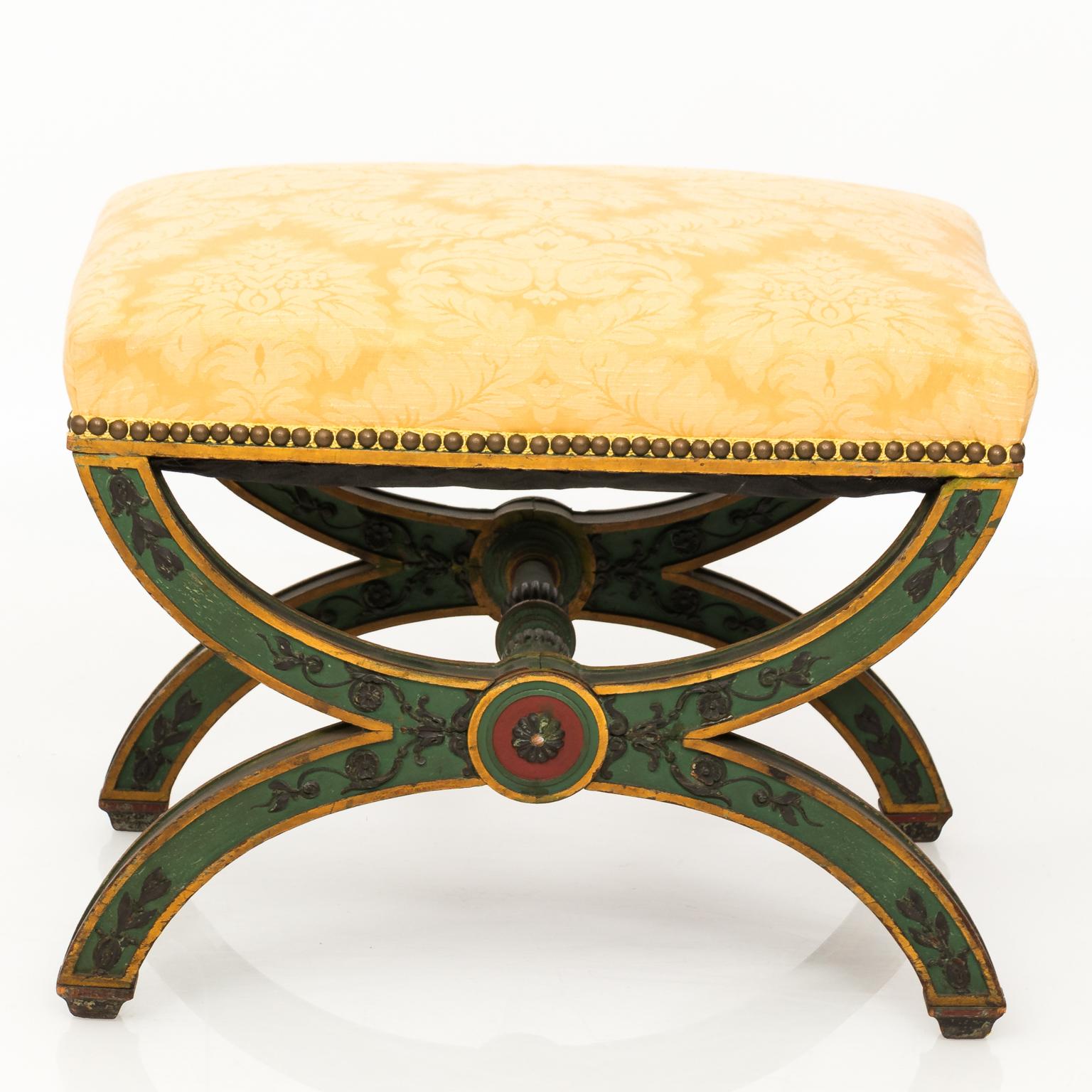 Pair of late19th century Curule style benches with carved and painted medallions and floral arabesques.
 