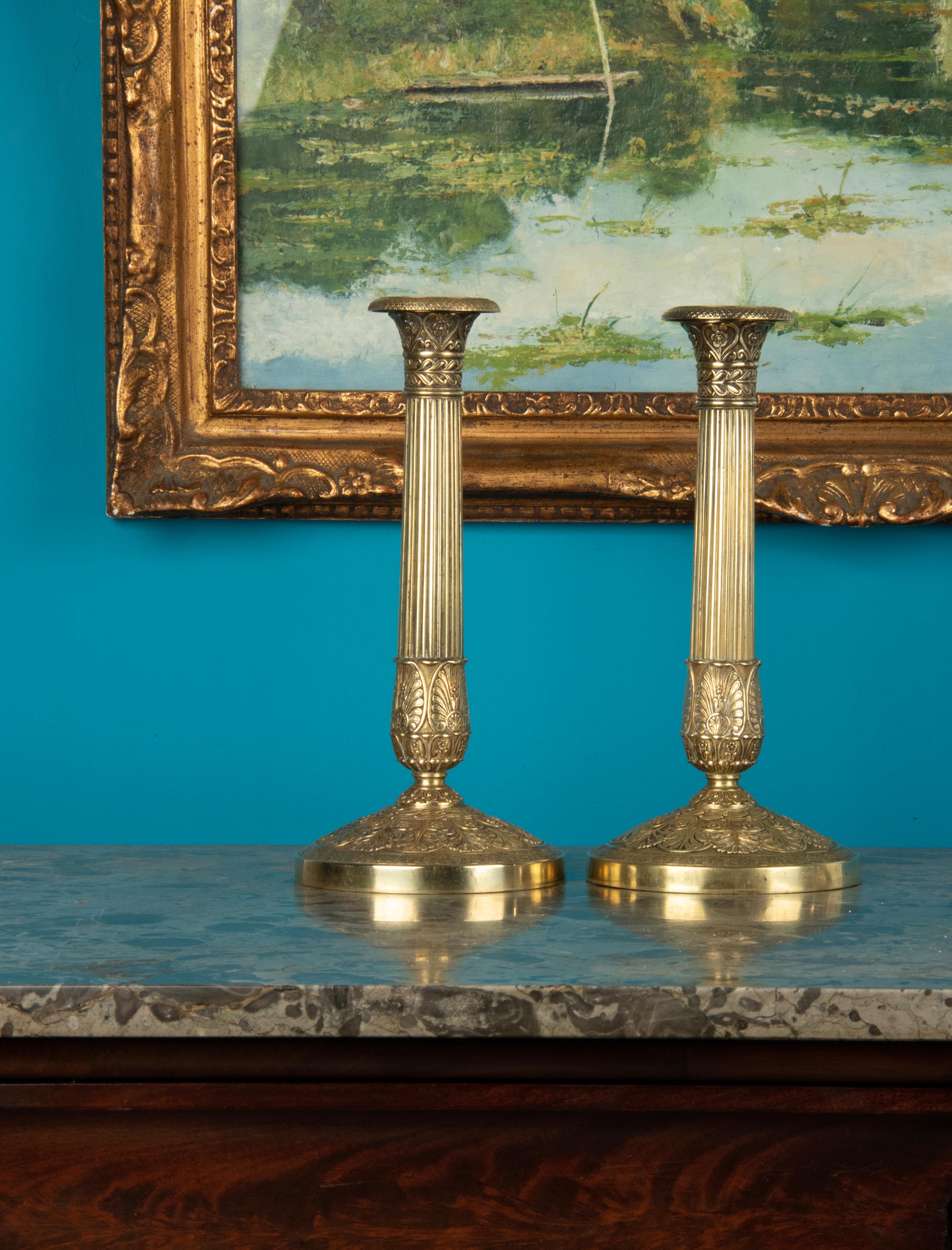 Ein Paar Kerzenleuchter aus Messing. Wunderschön verziert mit stilisierten Blumen und einem geriffelten Schaft im Empire-Stil. Die Kerzenhalter stammen aus der Zeit um 1880 bis 1890 und kommen aus Frankreich.