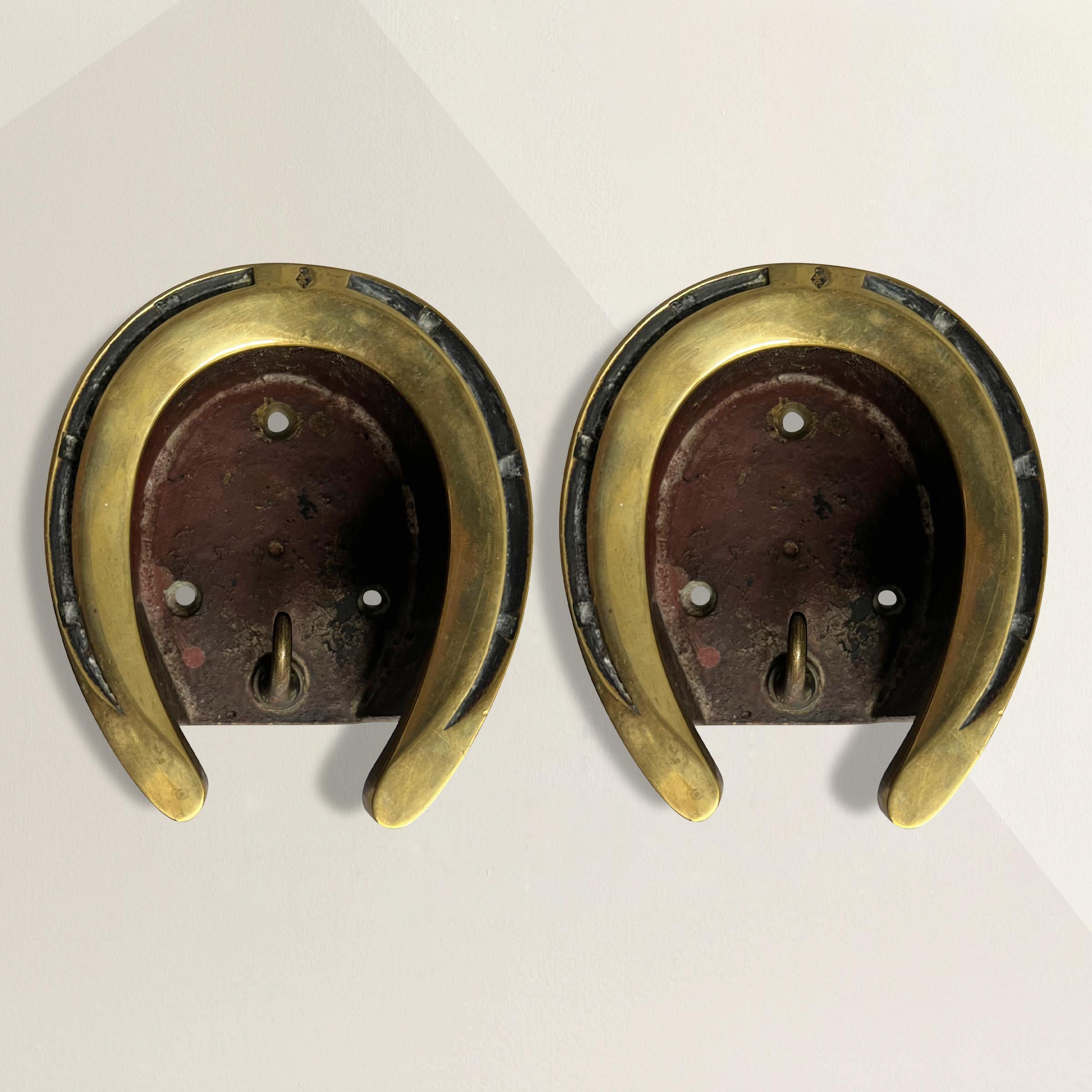 These late 19th century English brass bridle hooks are a charming nod to equestrian heritage and a testament to enduring craftsmanship. Each hook features a brass horseshoe proudly mounted on the face, symbolizing luck and the timeless bond between