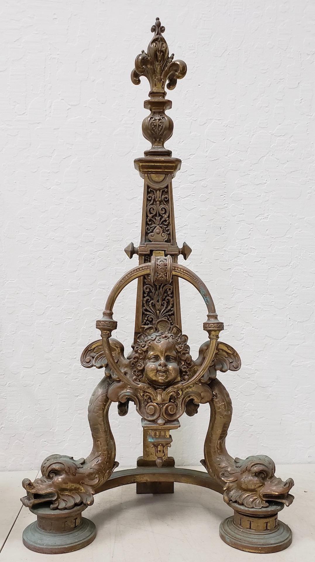 Pair of late 19th century French Baroque bronze chenets / andirons

Beautifully decorated with dolphin and putti. A fleur-de-lys sits on top of the obelisks.

These are in very good condition.

Each chenet measures 13