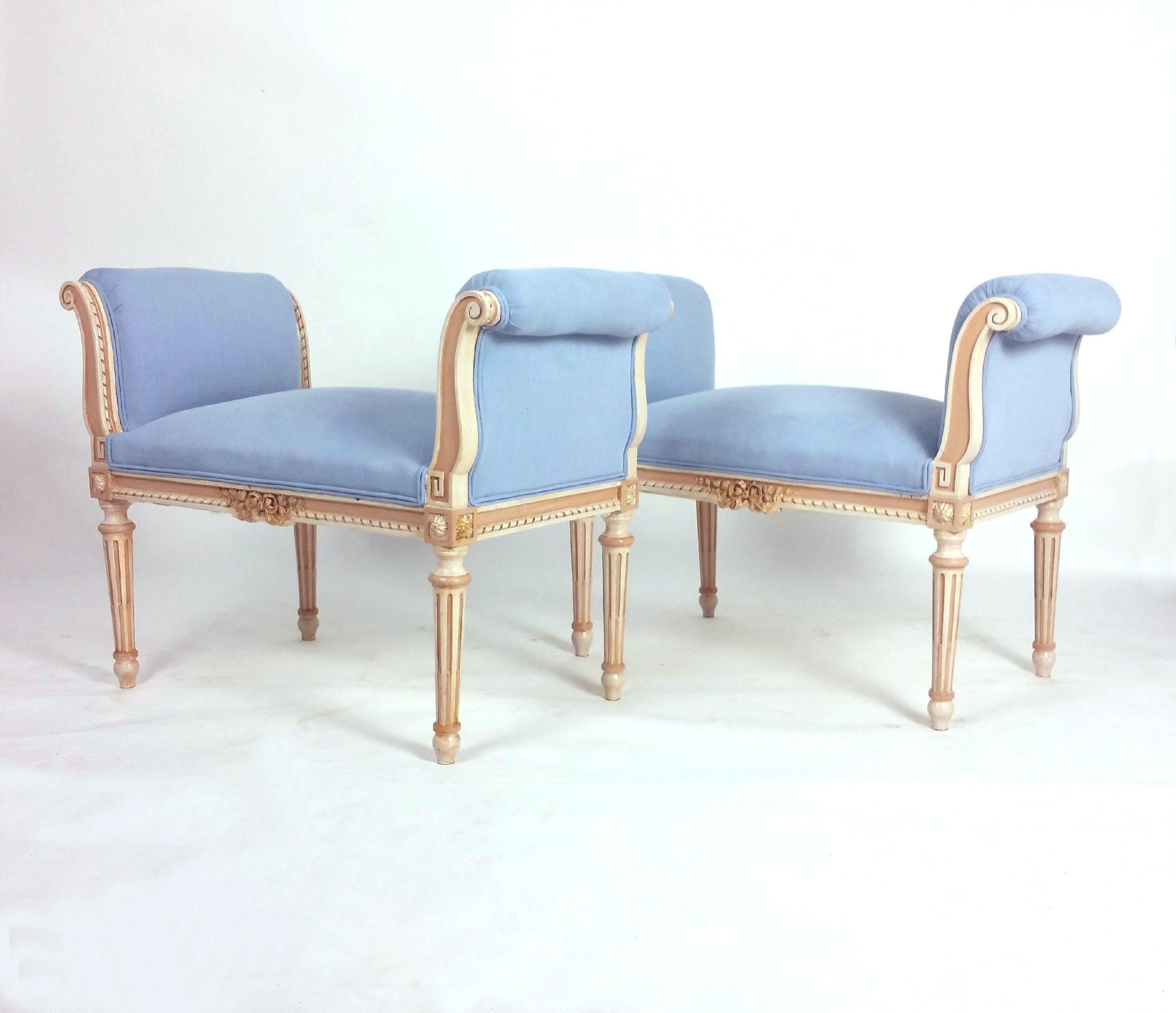 This splendid pair of late 19th century, French carved and painted window seats feature a very gracefully shaped design on fluted supports and upholstered in a soft baby blue linen blend with double piping trim. Each seat measures 35 in–89 cm wide,