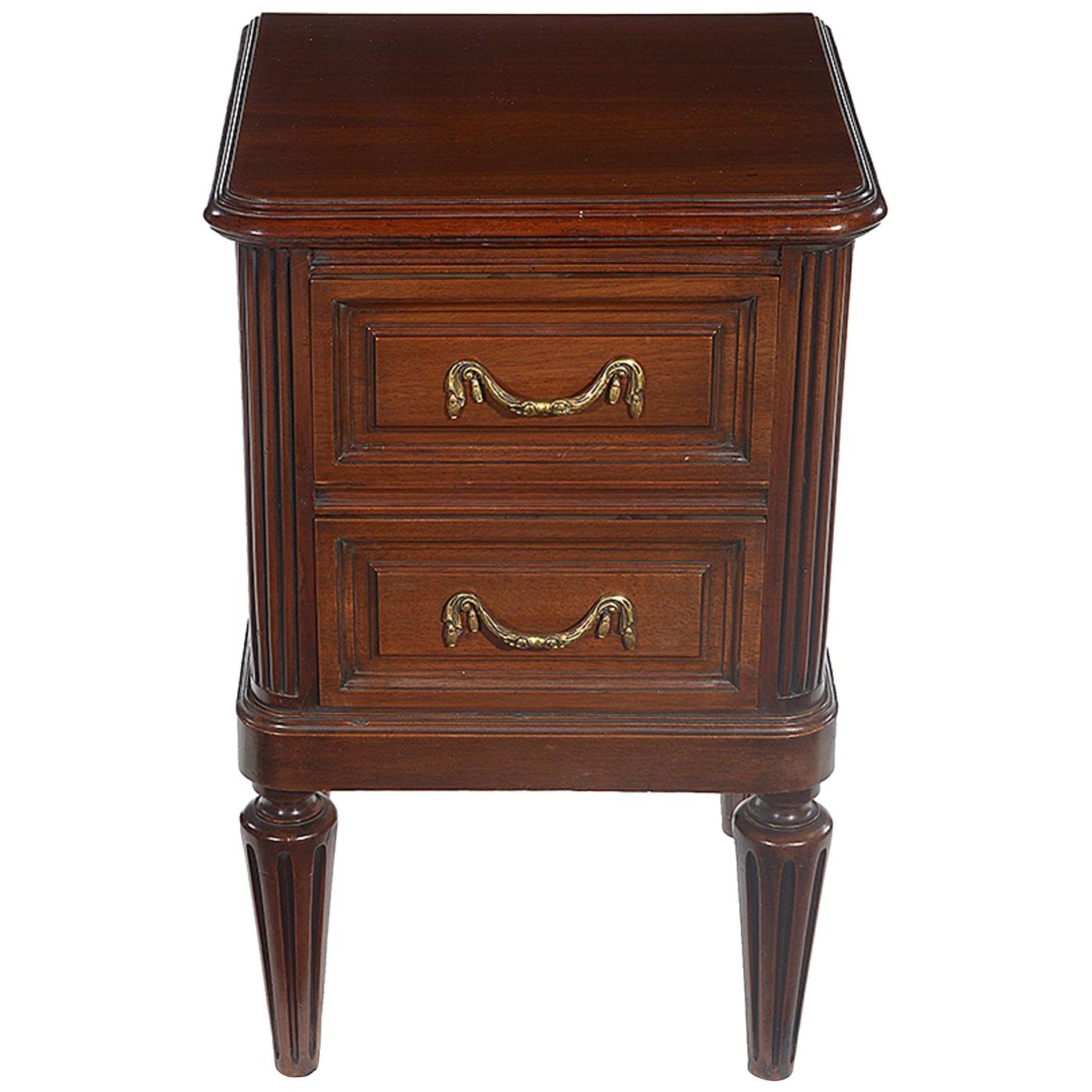 A pair of late 19th century French mahogany bedside chests.
The top with a moulded edge and two drawers furnished with brass swag handles below.
The whole raised on tapering fluted legs.

  