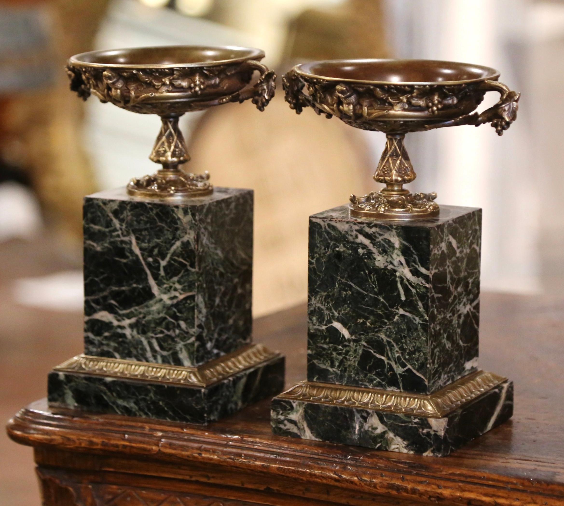 Catch loose change or other odds and ends with this pair of 19th century decorative tazza dishes. Crafted in France circa 1880, each compote sits on a square green marble base with repousse brass band at the bottom. The ornate vide-poche stands on a