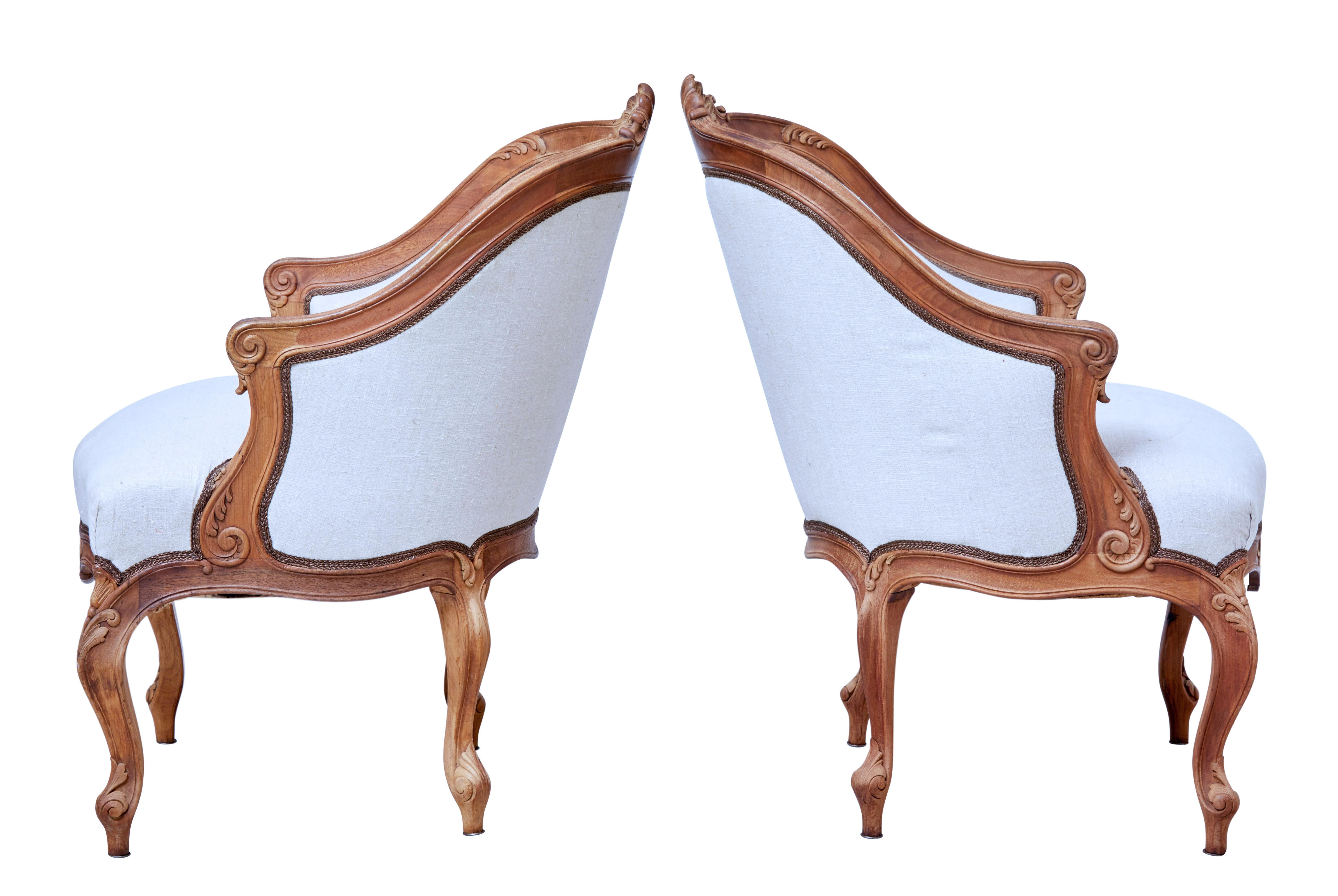 Good quality pair of French carved walnut armchairs, circa 1890.

Presented in bare walnut having been previously stripped back. Deep carved shell and swags to the shaped back, leading down to the acanthus leaf detail on the arm. Further carved