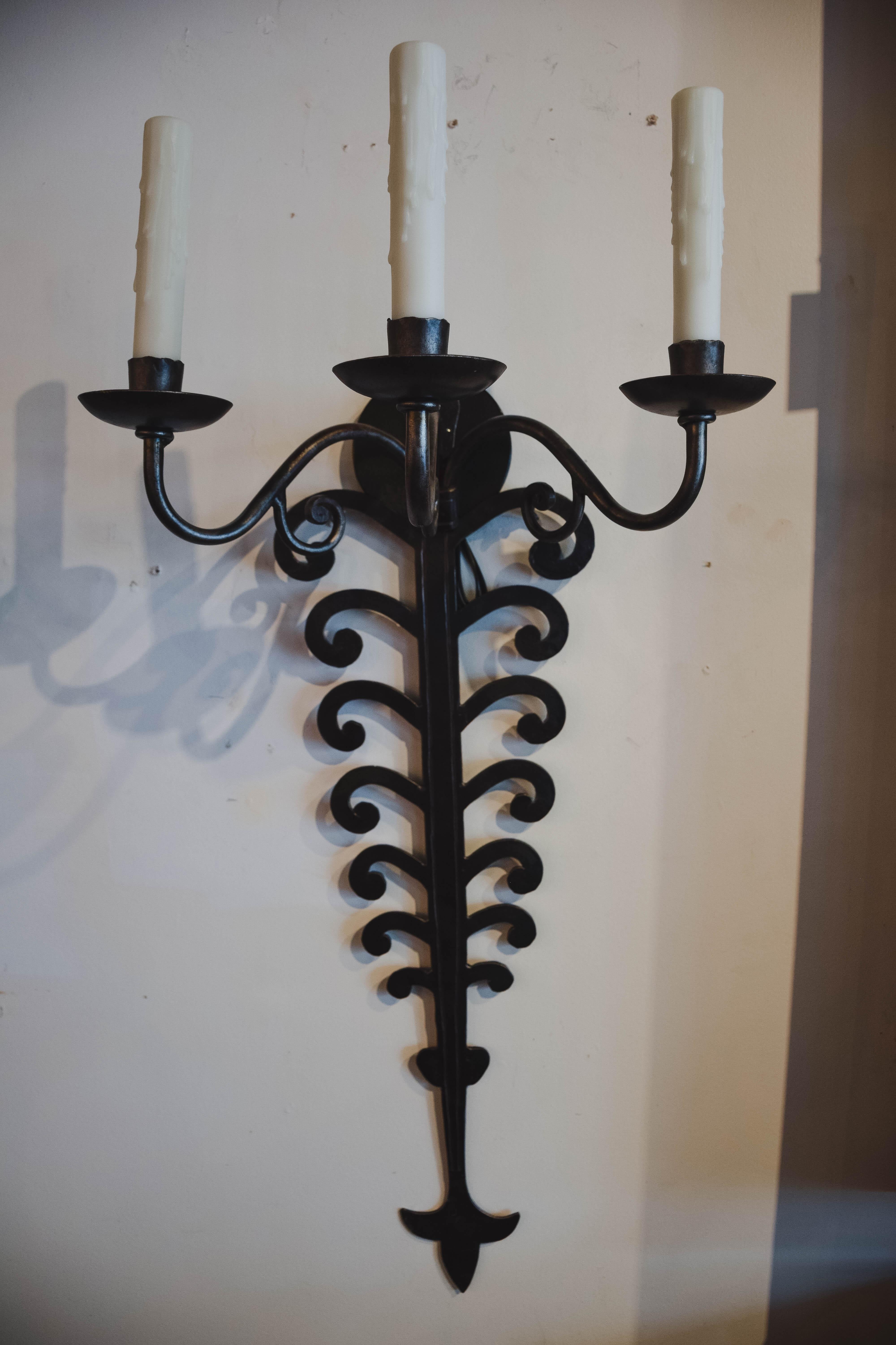 Found in France, these dramatic iron sconces are definite statement pieces. Hand forged in the late 19th century to once hold candles, the sconces have been newly wired to United States standards.