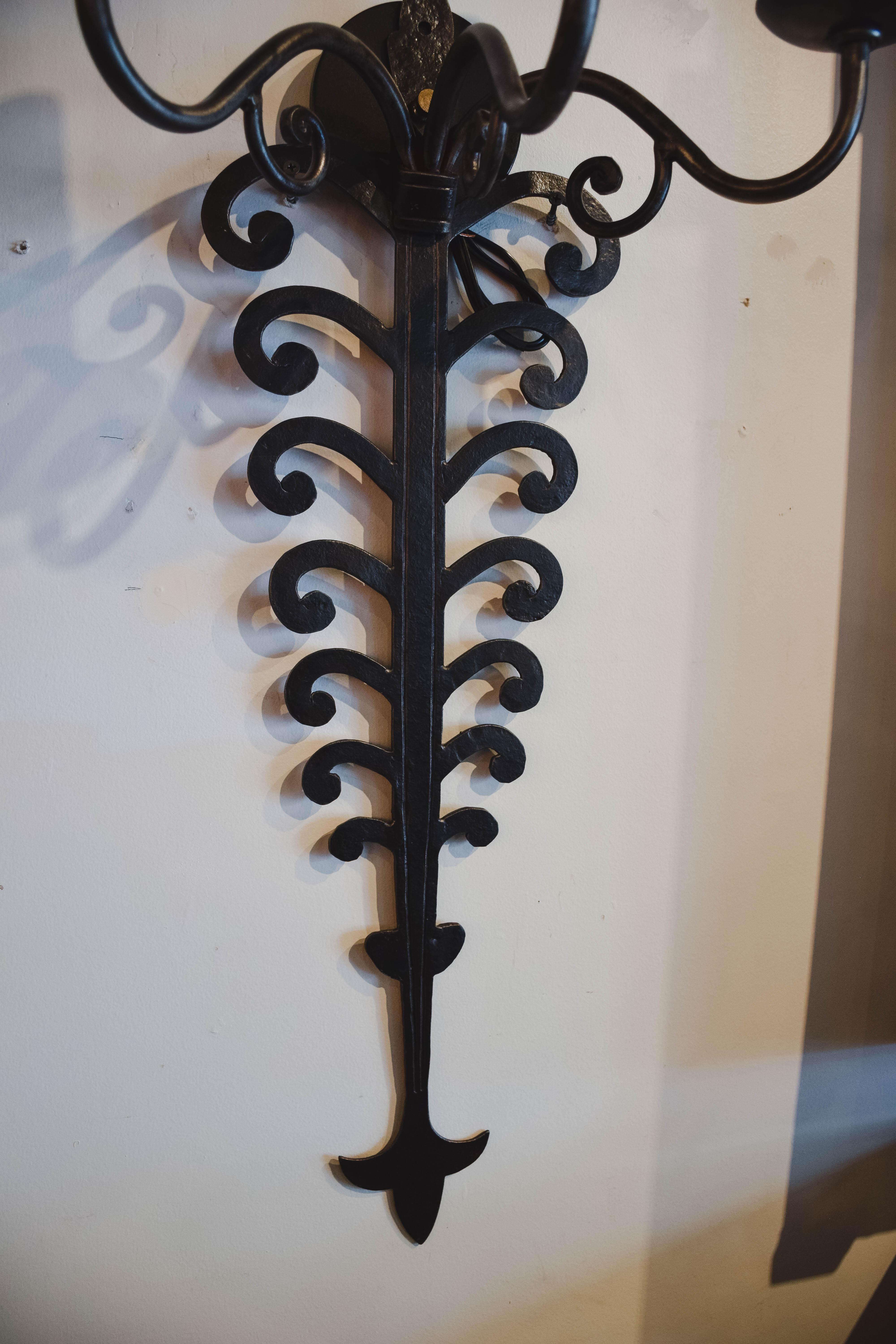 Found in France, these dramatic iron sconces are definite statement pieces. Hand forged in the late 19th century to once hold candles, the sconces have been newly wired to United States standards.