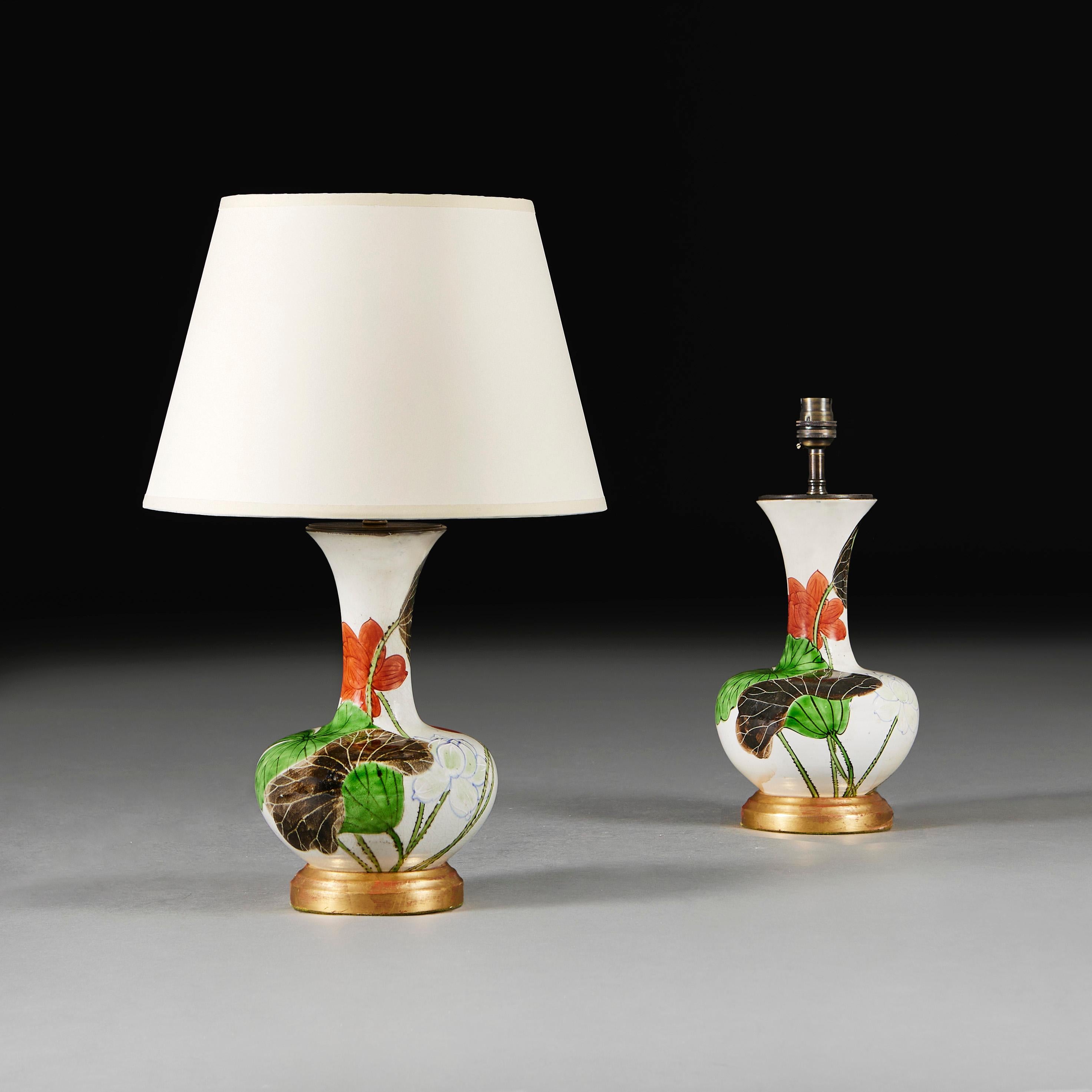 An unusual pair of late nineteenth century Japanese vases decorated with lotus flowers on a white ground, now mounted as lamps with turned giltwood bases.

Please note:
Lamps have been photographed with a 14” pale cream Pembroke card