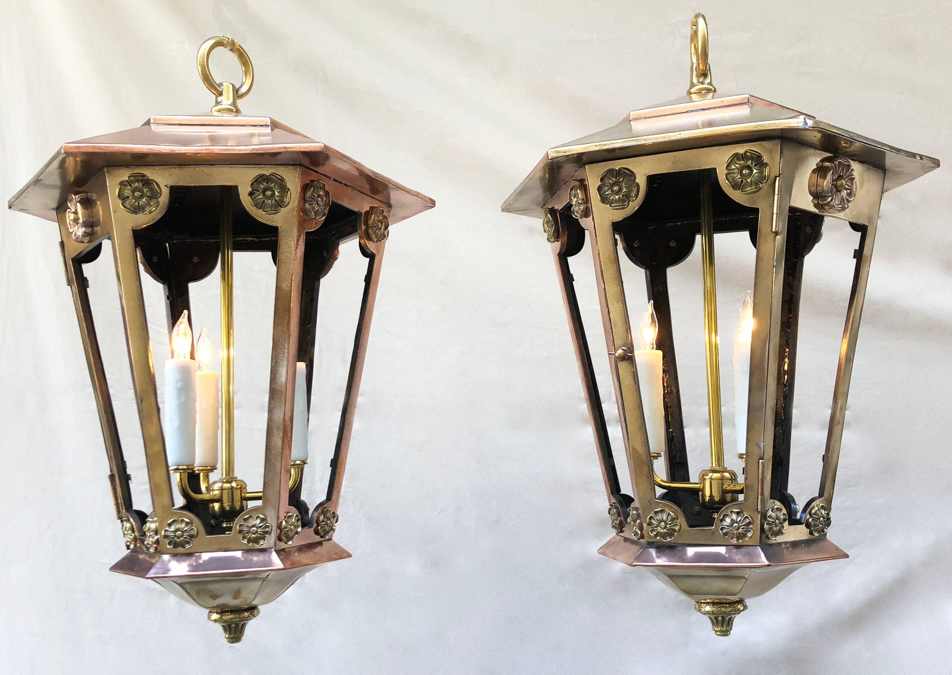 Wonderful pair of late 19th century New York copper and brass gas lanterns attributed to Caldwell. Decorative rosettes adore the lantern. Lanterns can be used inside or outdoors.

Canopy and chain included. Rewired and electrified.