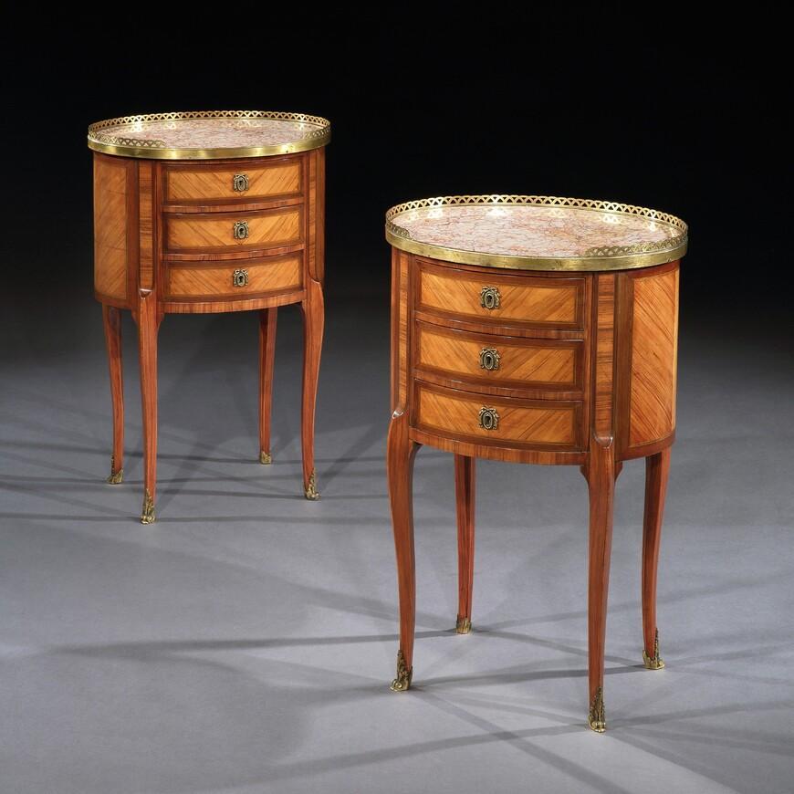 A fine and attractive pair of French oval kingwood and amaranth tables en chiffonier / night stands with marble tops stamped P. Chorier. 

Late 19th-early 20th century, circa 1900.

These extremely well made pair of side tables often used as