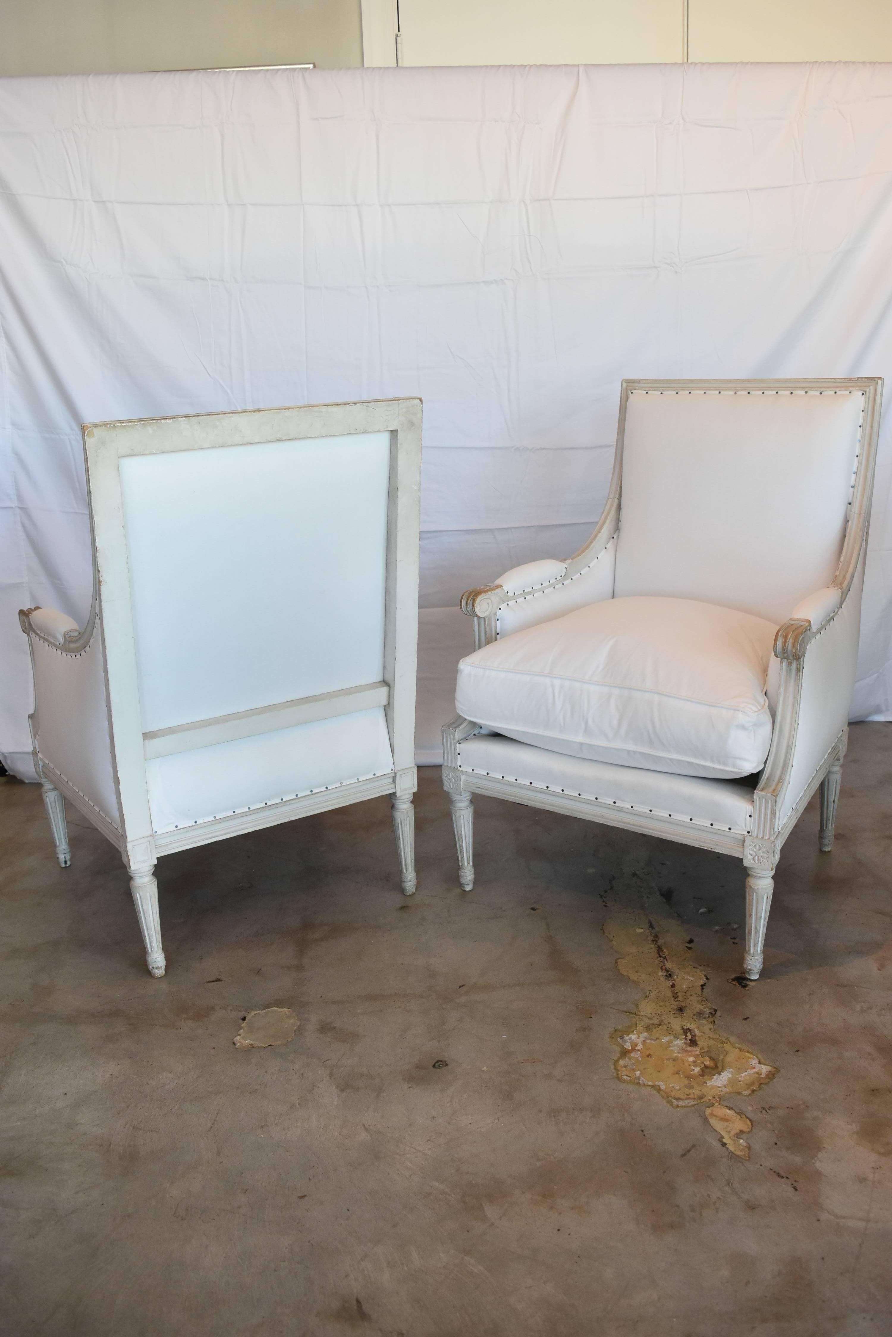 These late 19th century Louis XVI chairs from France are a great example of classic design that is timeless. The clean lines work with any decor. The paint on these is a cross between a greyed white and grey. The fabric is barely off white muslin