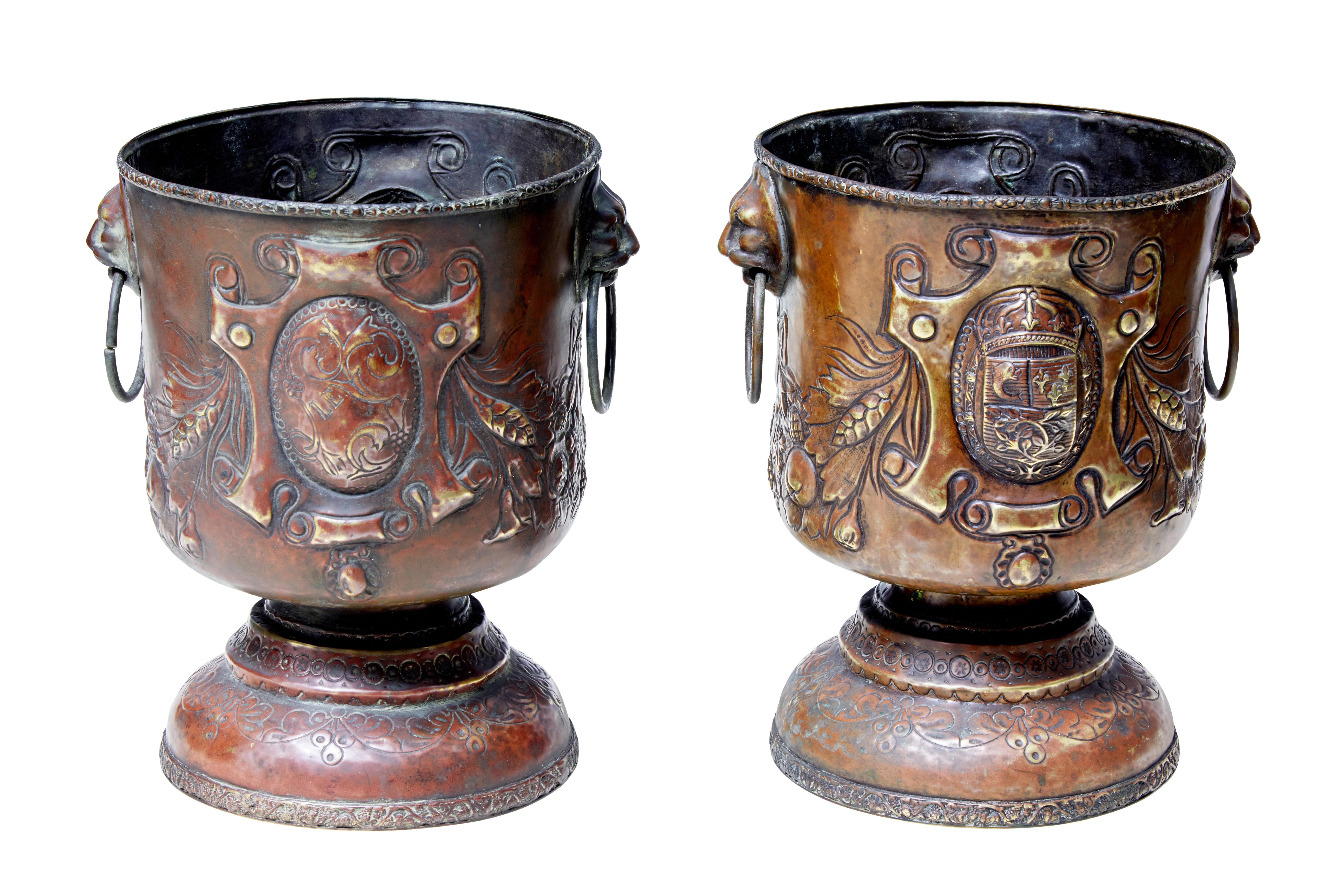 Pair of continental copper wine coolers or small jardinières, circa 1890.

Made using the repoussé technique. Decorated with armorial cartouches. Cup shape with lion mask ringed handles to the sides, standing on a domed base.

Rubbing to patina