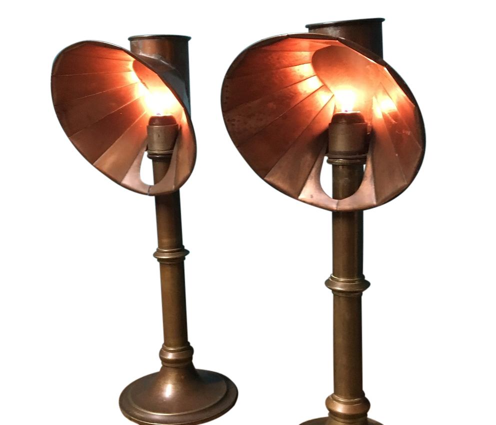 A beautiful pair of spring loaded brass candle stands with copper reflector hoods. This pair is by Miller's of London and are in very nice original condition, as the candle burns the spring pressure pushes the candle up automatically thus keeping