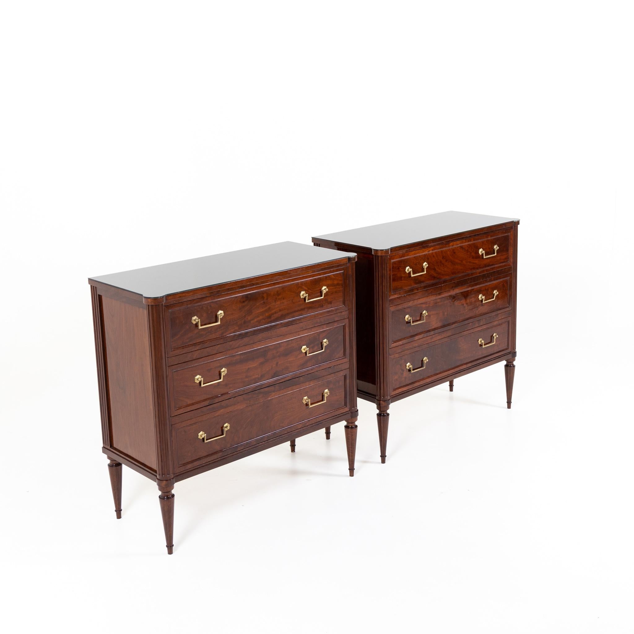 Pair of Late 19th Century Three Drawer chests with glass tops.
Mahogany with fluted details, brass pulls,
and contemporary black glass tops.