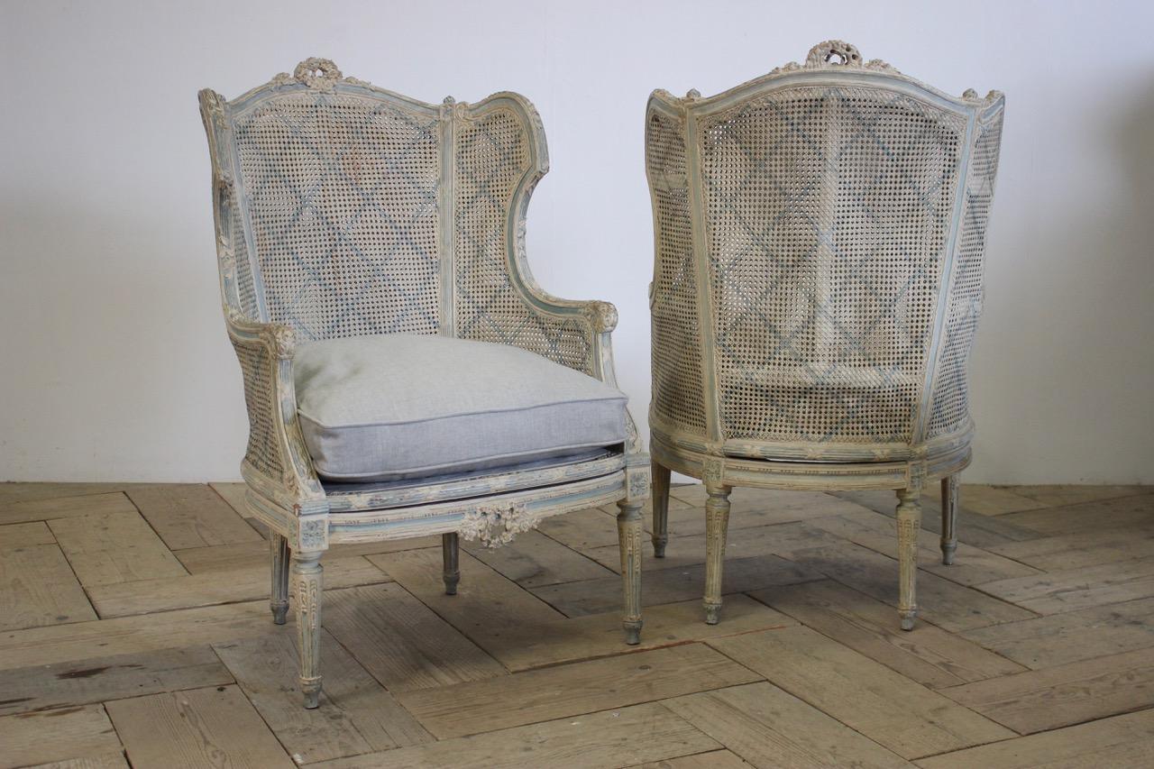 A pair of late 19th-early 20th century French painted caned bergeres in the Louis XVI taste, retaining the original decoration and with new linen cushions.
Small repairs to the cane.
Measurements: 54 cm high (floor to seat),
France.
 