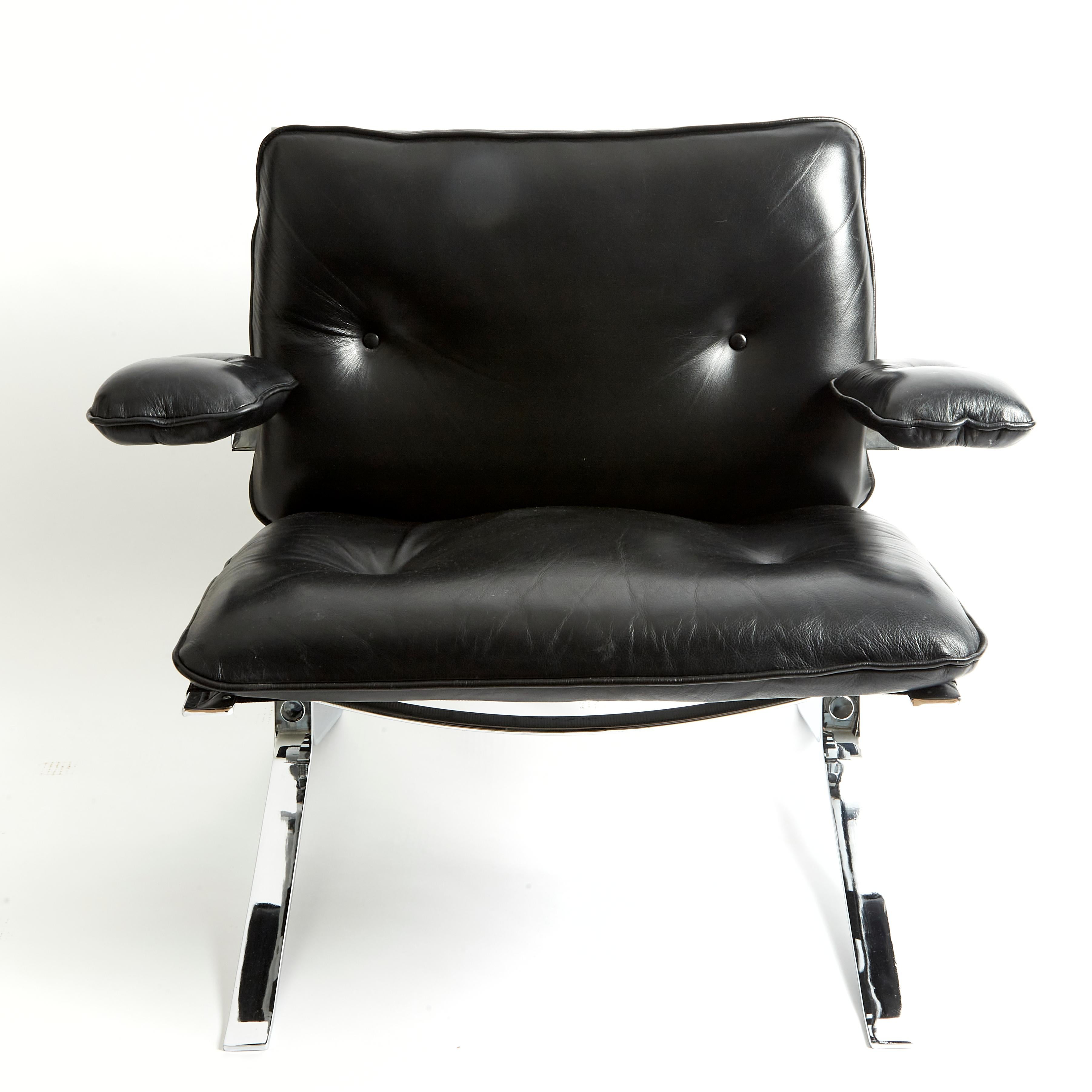 These streamlined and very good looking pair of black leather and chrome chairs features a padded seat, back and armrests. They are supported on a modern chrome frame with a light button detailing. Each chair measures 31 in – 78.7 cm wide, 27 ½ in –