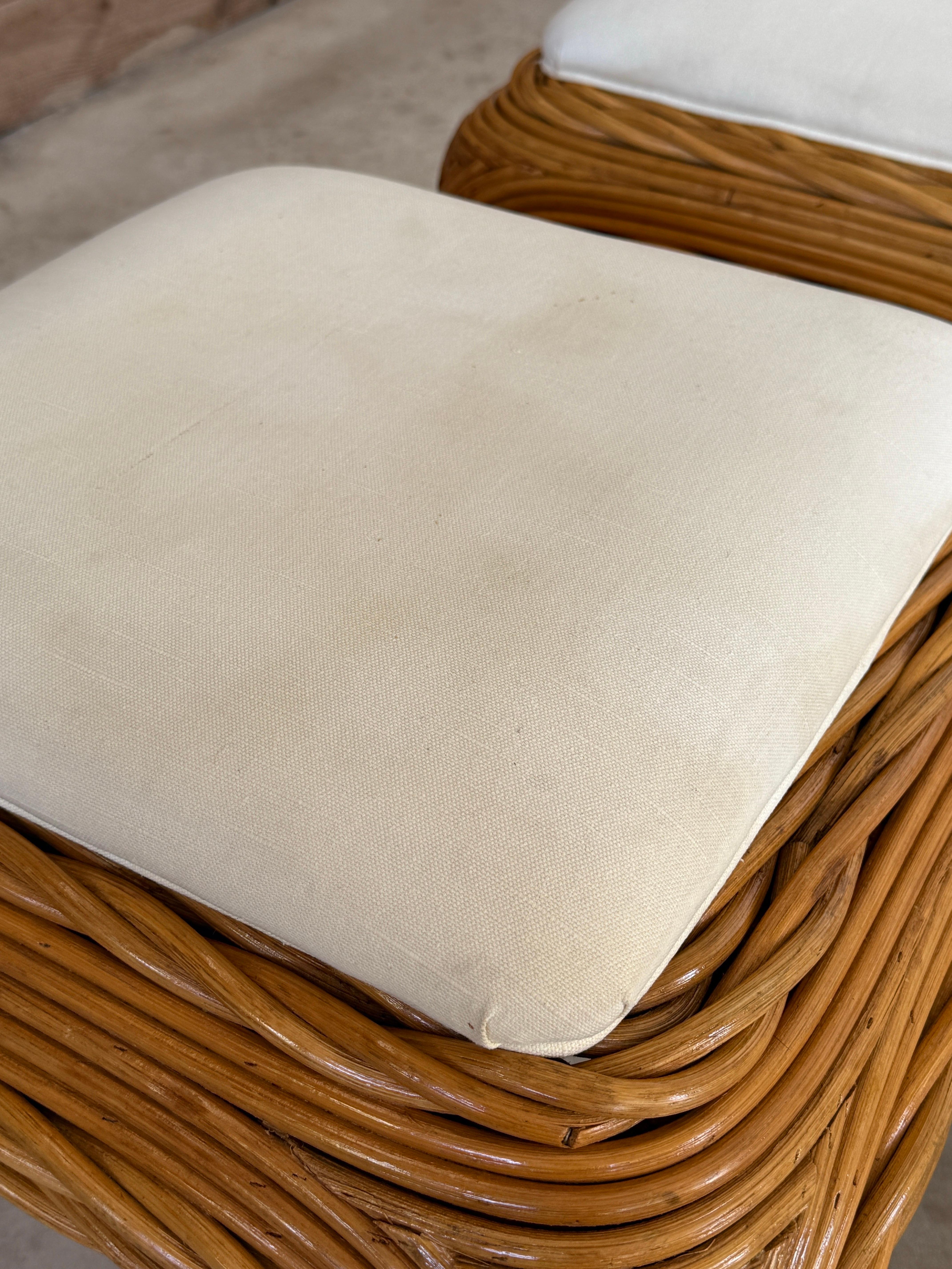 Paire sculpturale d'ottomans ou de poufs en rotin de la fin du 20e siècle, de style Organic Modern, avec une base en rotin torsadée à la main, des pieds joliment arqués et une silhouette fluide.
Les bases ont été professionnellement remises à neuf,